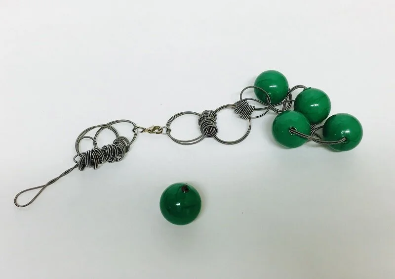 A client had this unique and fun piece that unfortunately broke.  She asked me if I would be able to repair it as best as possible as she really liked it.
(those are all very tiny metal springs in between the green glass beads.)