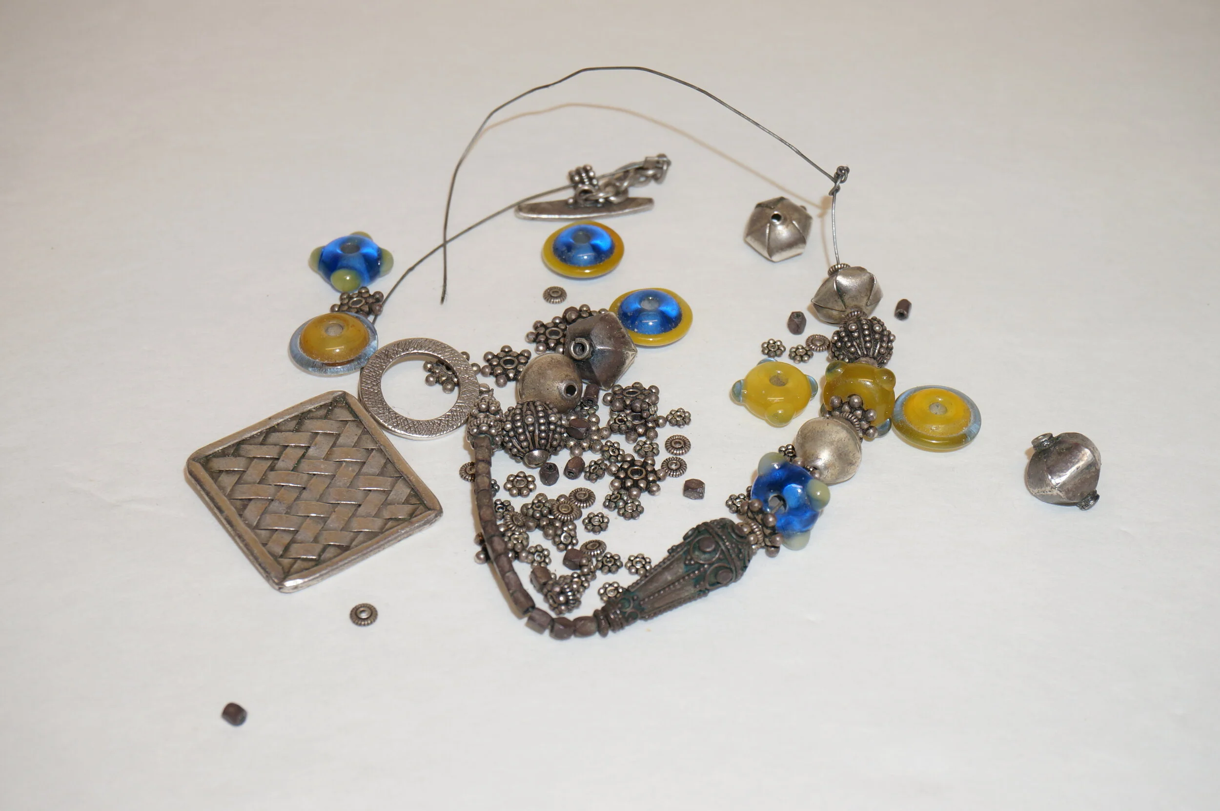 A woman approached me at an art show with a bag that contained a broken necklace.  She shared she did not remember what it looked like originally, and requested I make something with it as the bag is just sitting in her drawer.