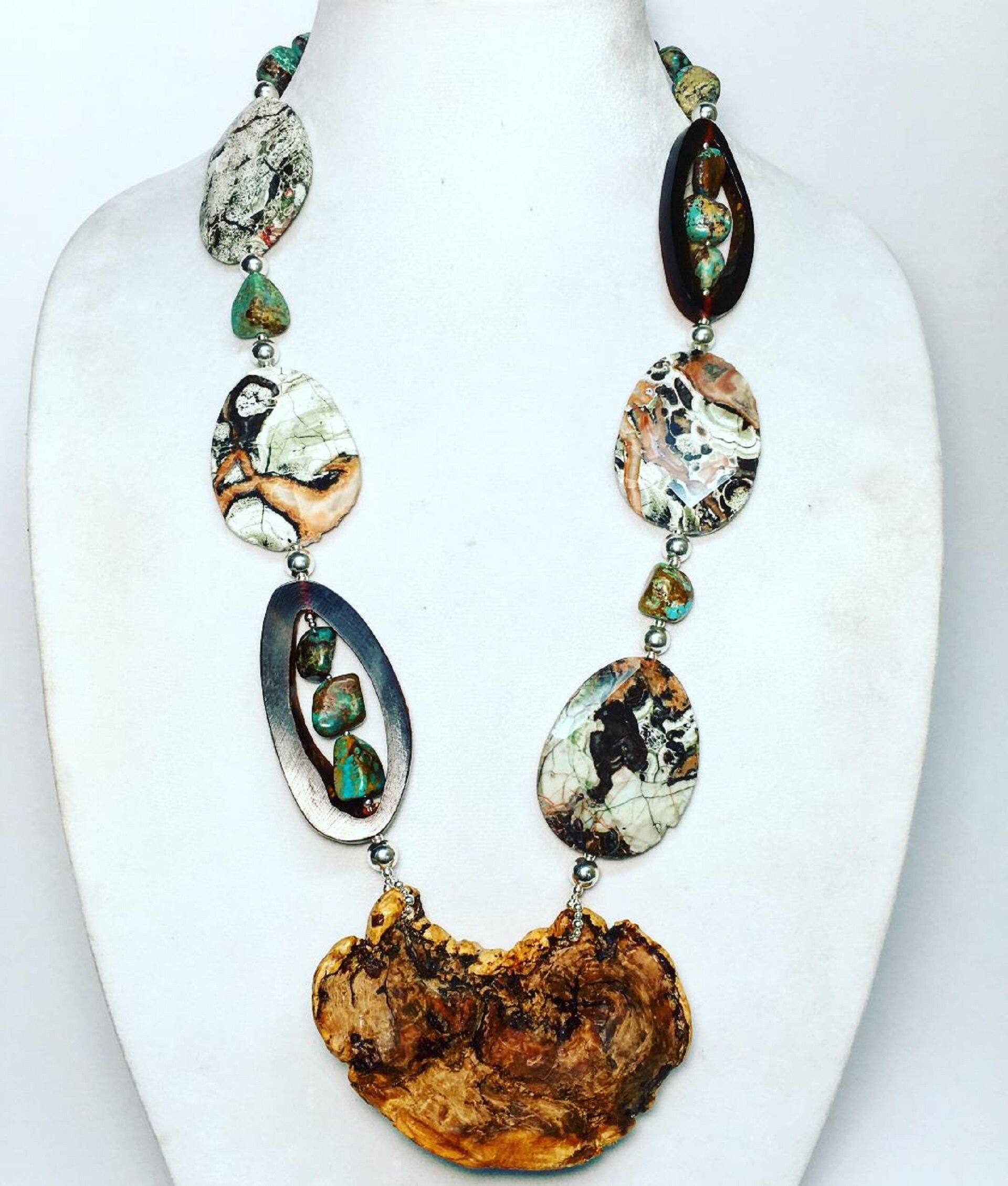 My client gave me the piece of wood- that is the focal pendant and asked me to create something around it.  The wood had significance as it is a piece of petrified wood from South America and from a client of hers.
Used:  Petrified wood, mushroom jas