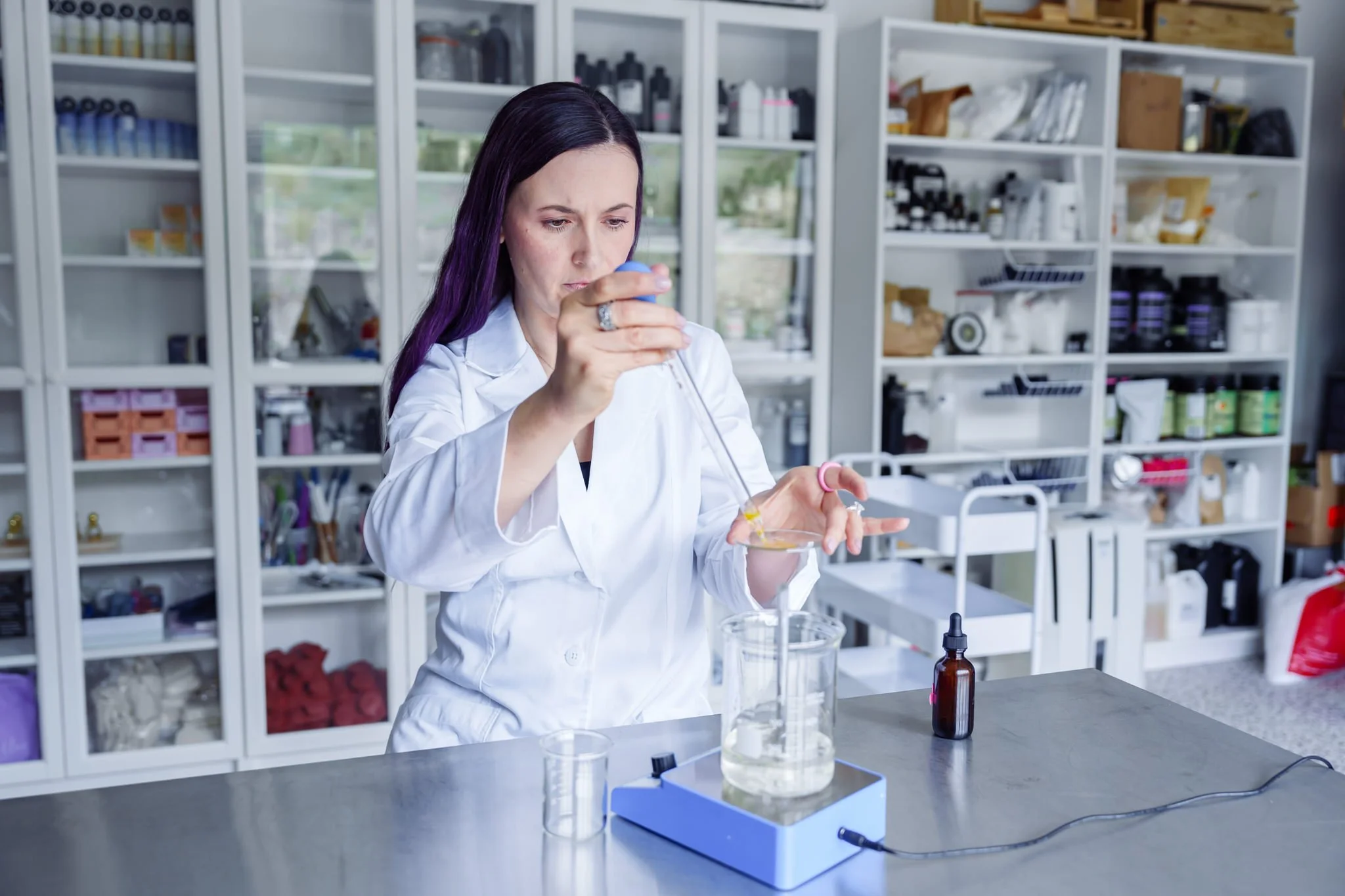 Scientist in a lab measuring liquid with a pipette