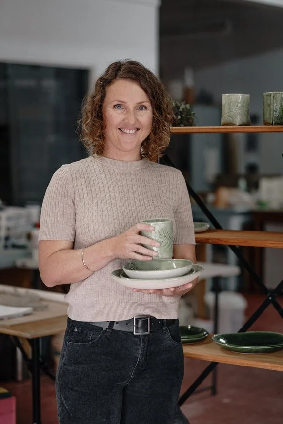 Person holding ceramic pottery in a studio