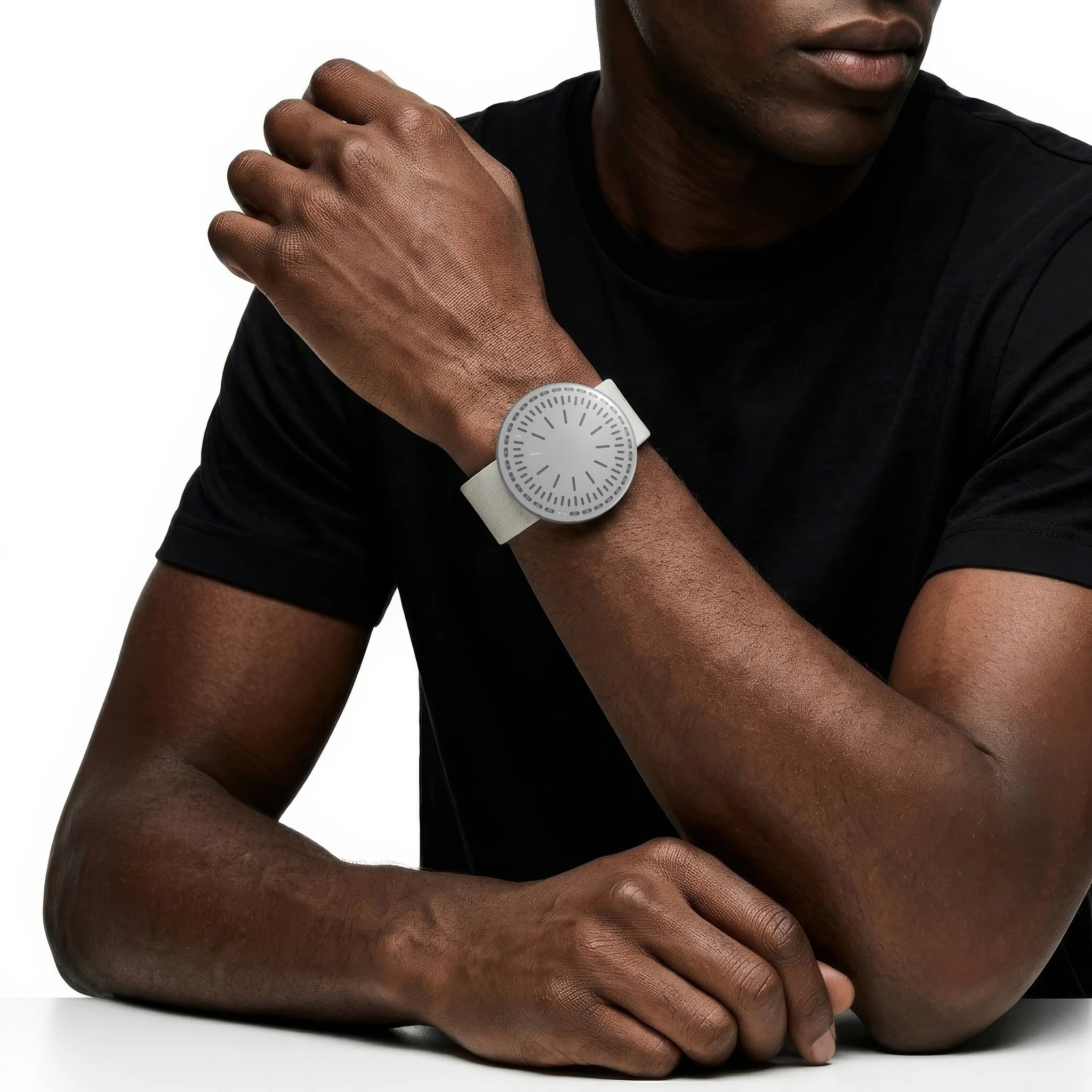 RVNDSGN watch with grey dial and grey leather strap on a mans wrist.