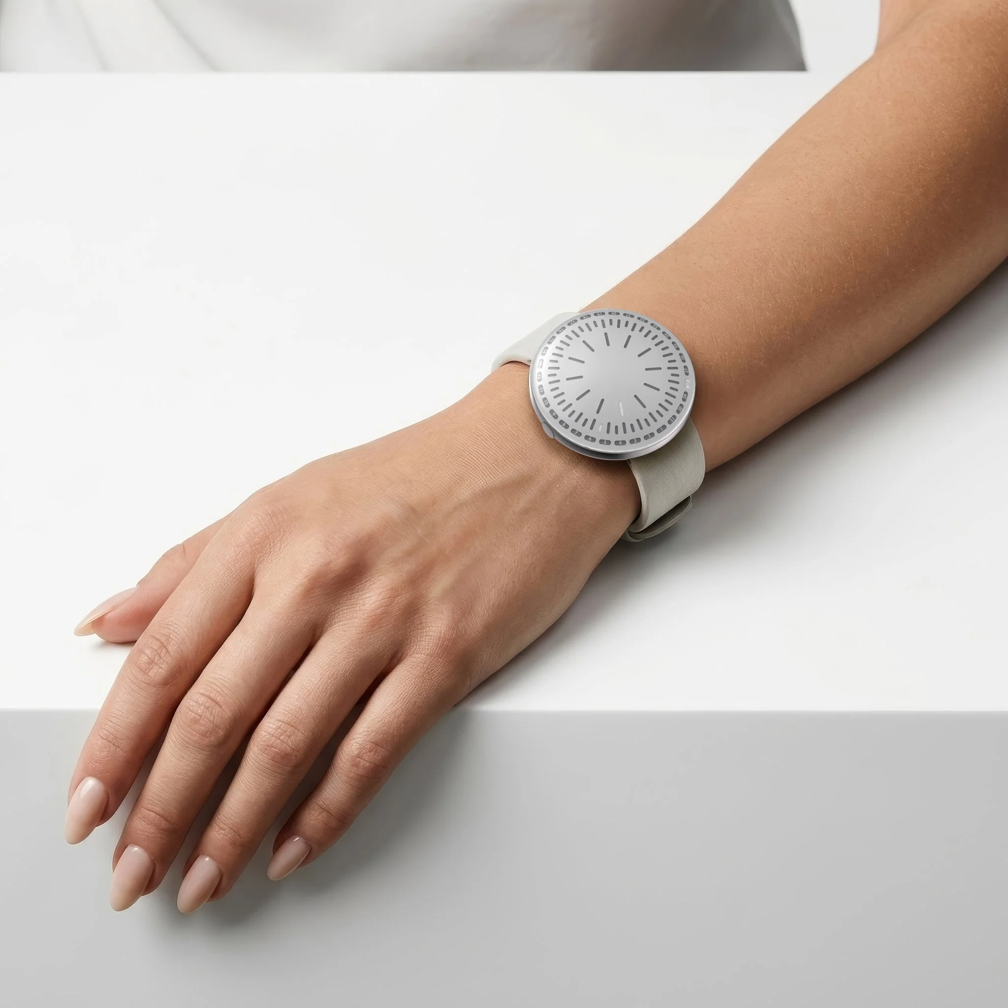 RVNDSGN watch with grey dial and grey leather strap on a womans wrist.