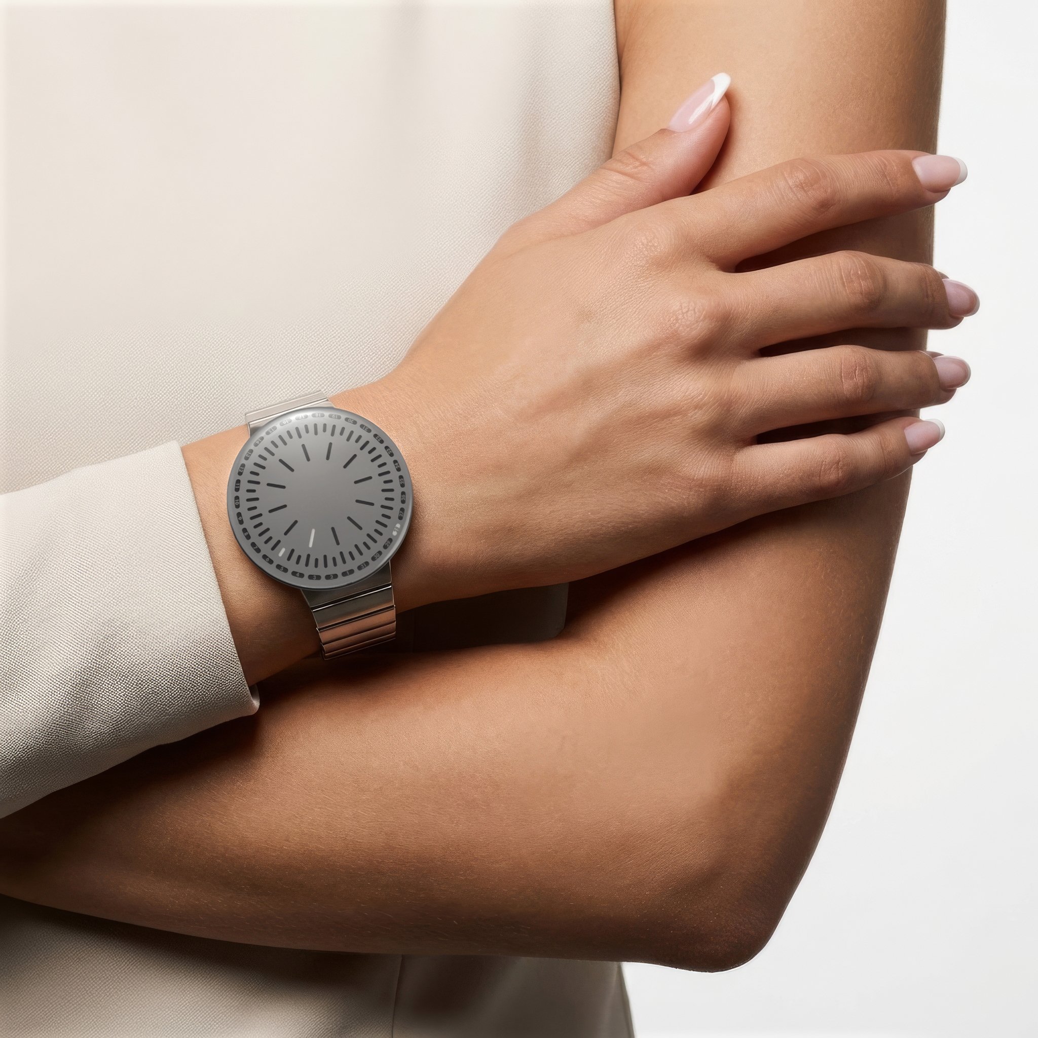 RVNDSGN watch with grey dial and steel bracelet on a womans wrist.