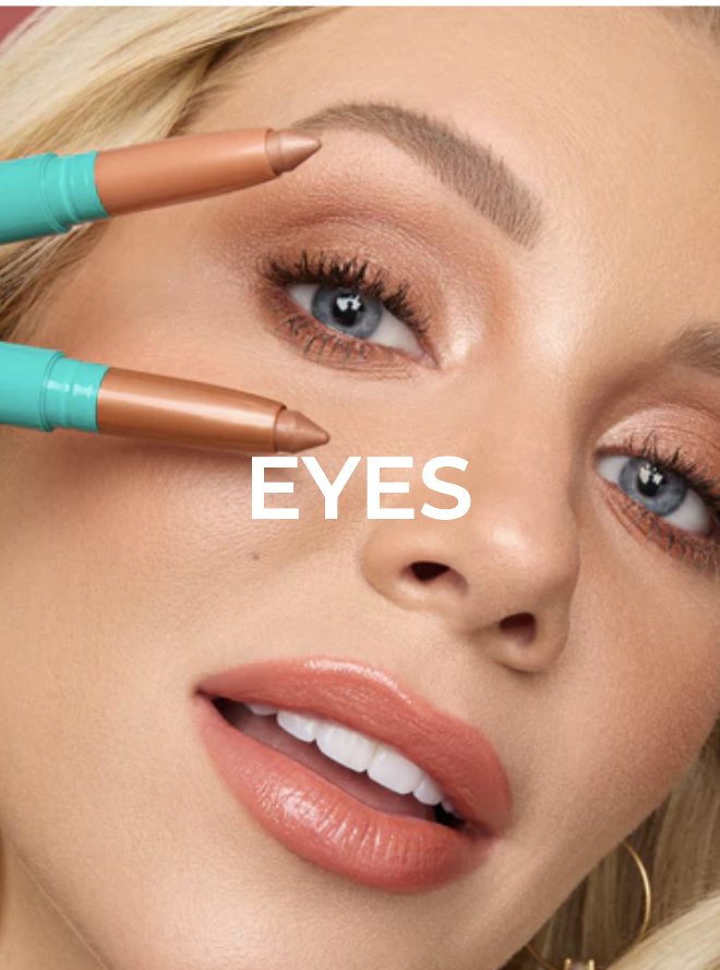 Woman holding two gold colored eyeshadow pencils