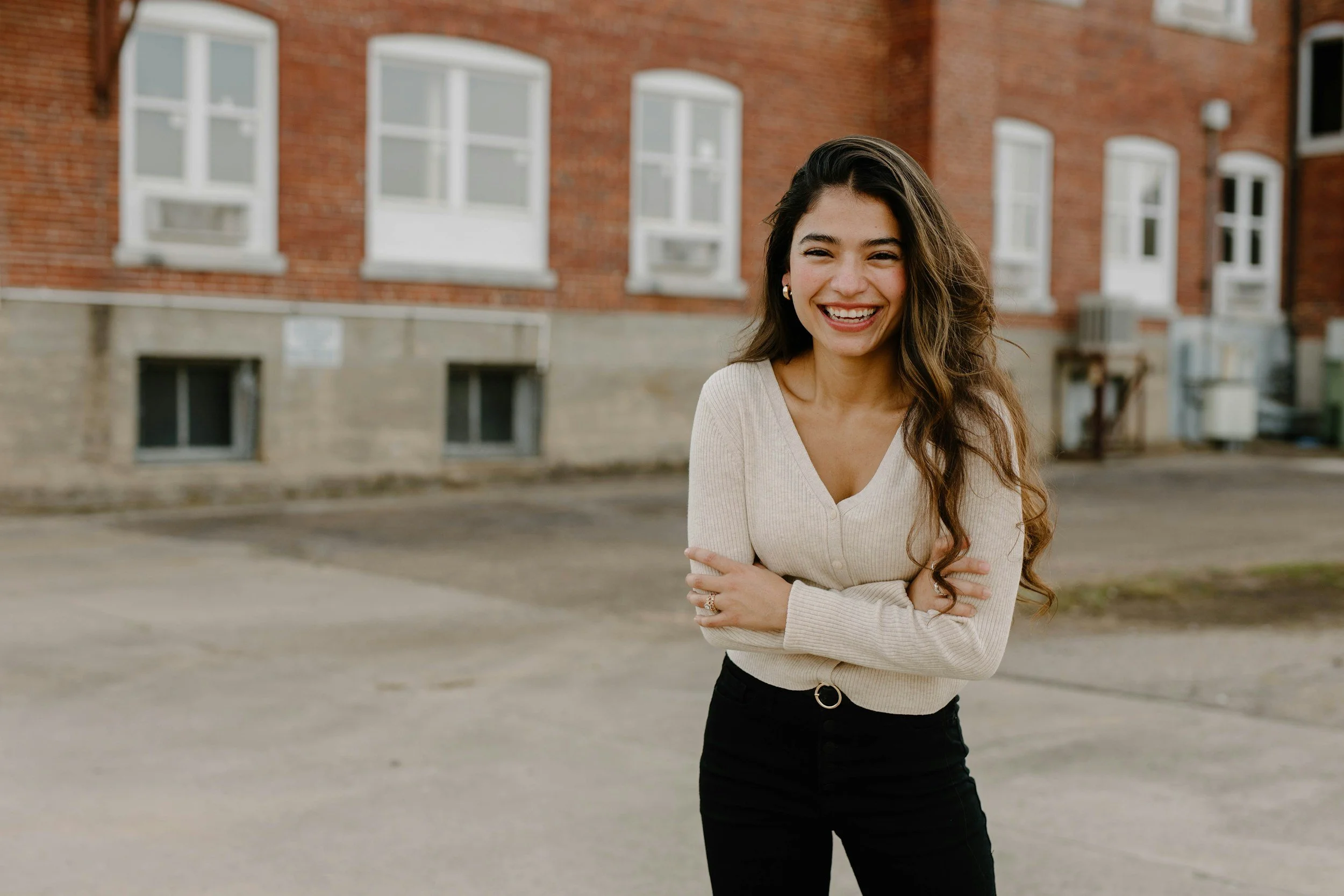 young hispanic woman in front of a school