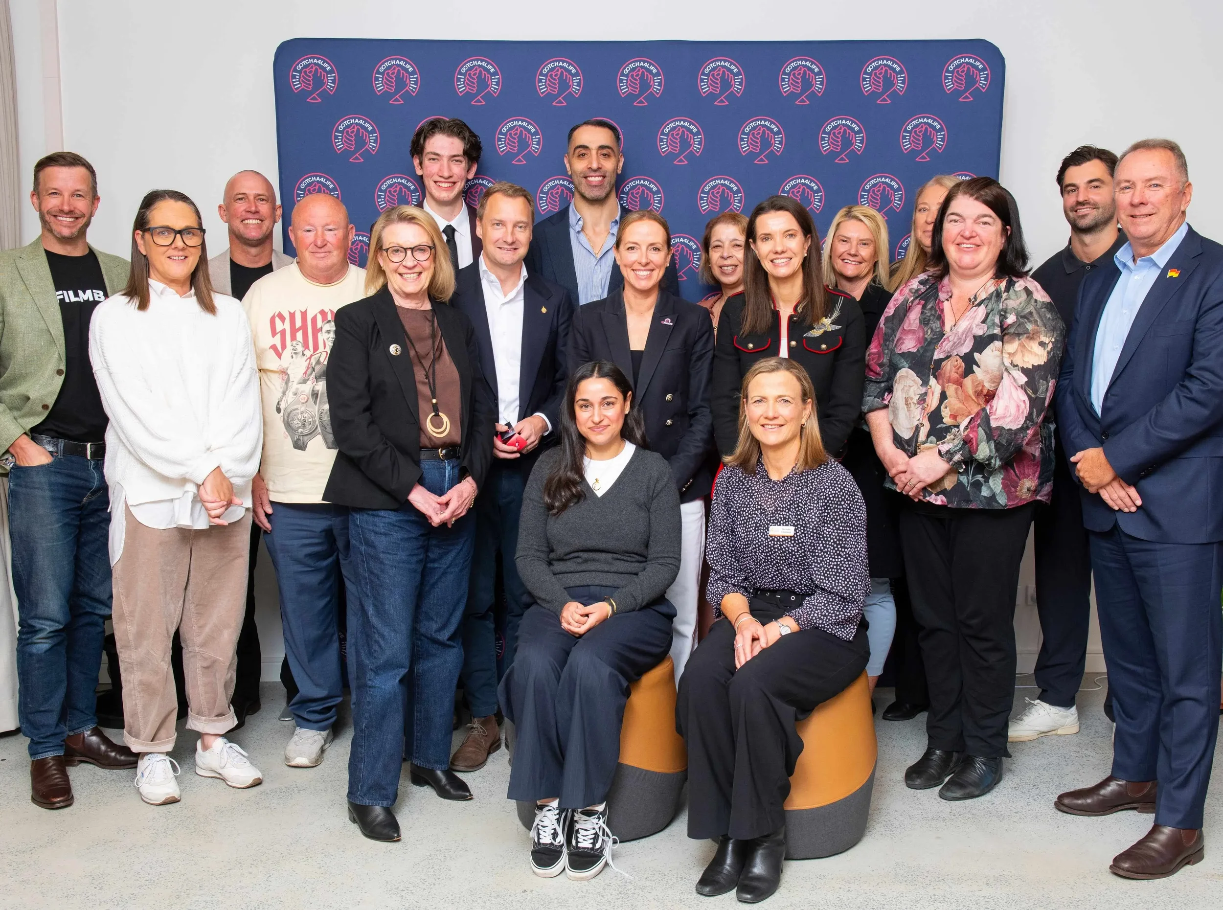 Award recipients of Gotcha4Life's  Mental Fitness Leadership Awards standing together for a photo in front of Gotcha4Life's branded media wall.