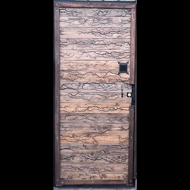 Custom door completed. 
Lichtenberg figures on cedar planks with a dark walnut stain.