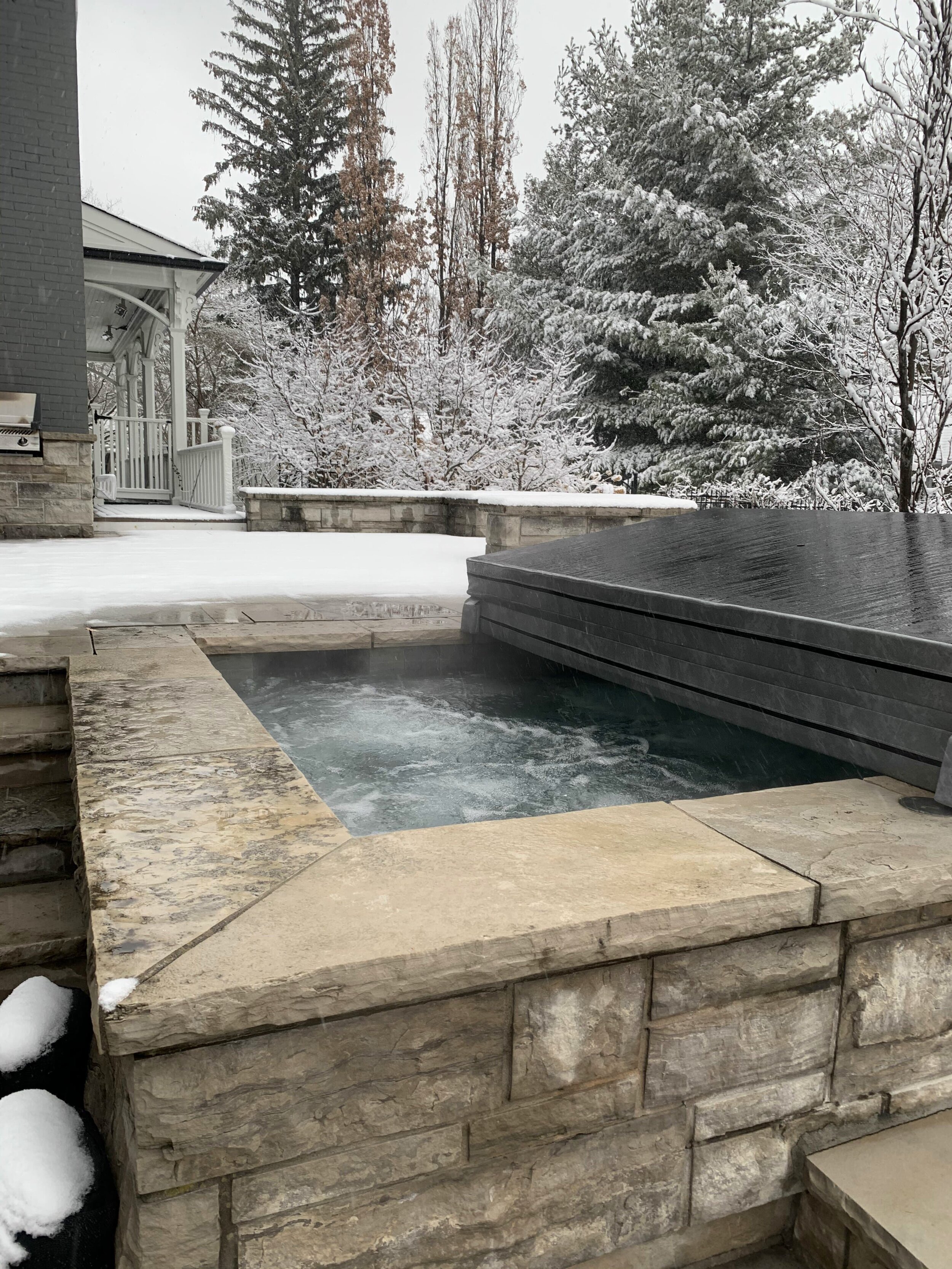 Heated outdoor water feature operating in winter conditions, maintaining warm water through snow-covered surroundings.