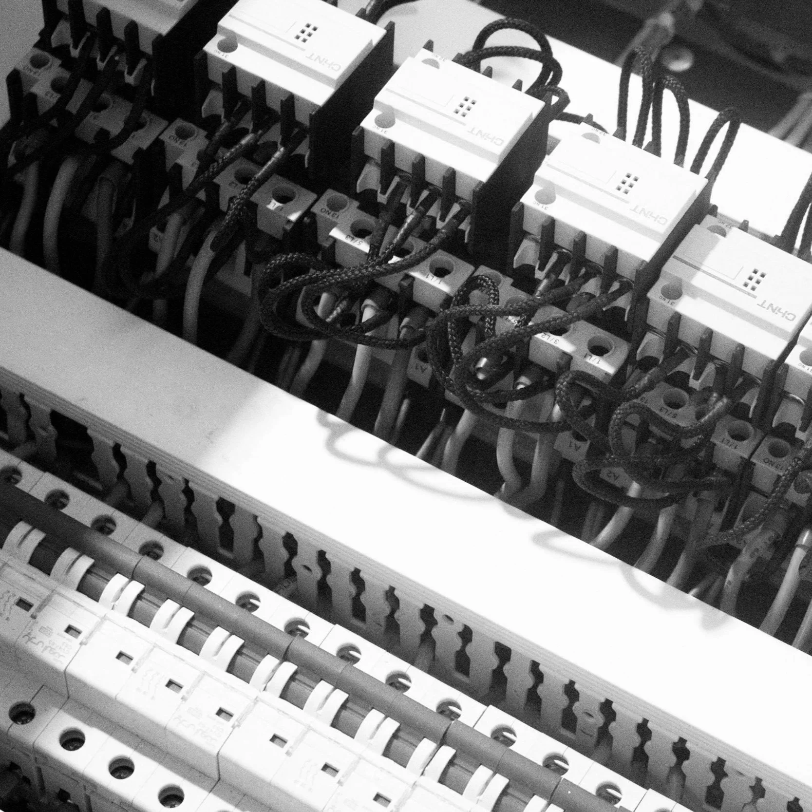 Close-up of an electrical breaker panel with multiple circuit breakers and wires.