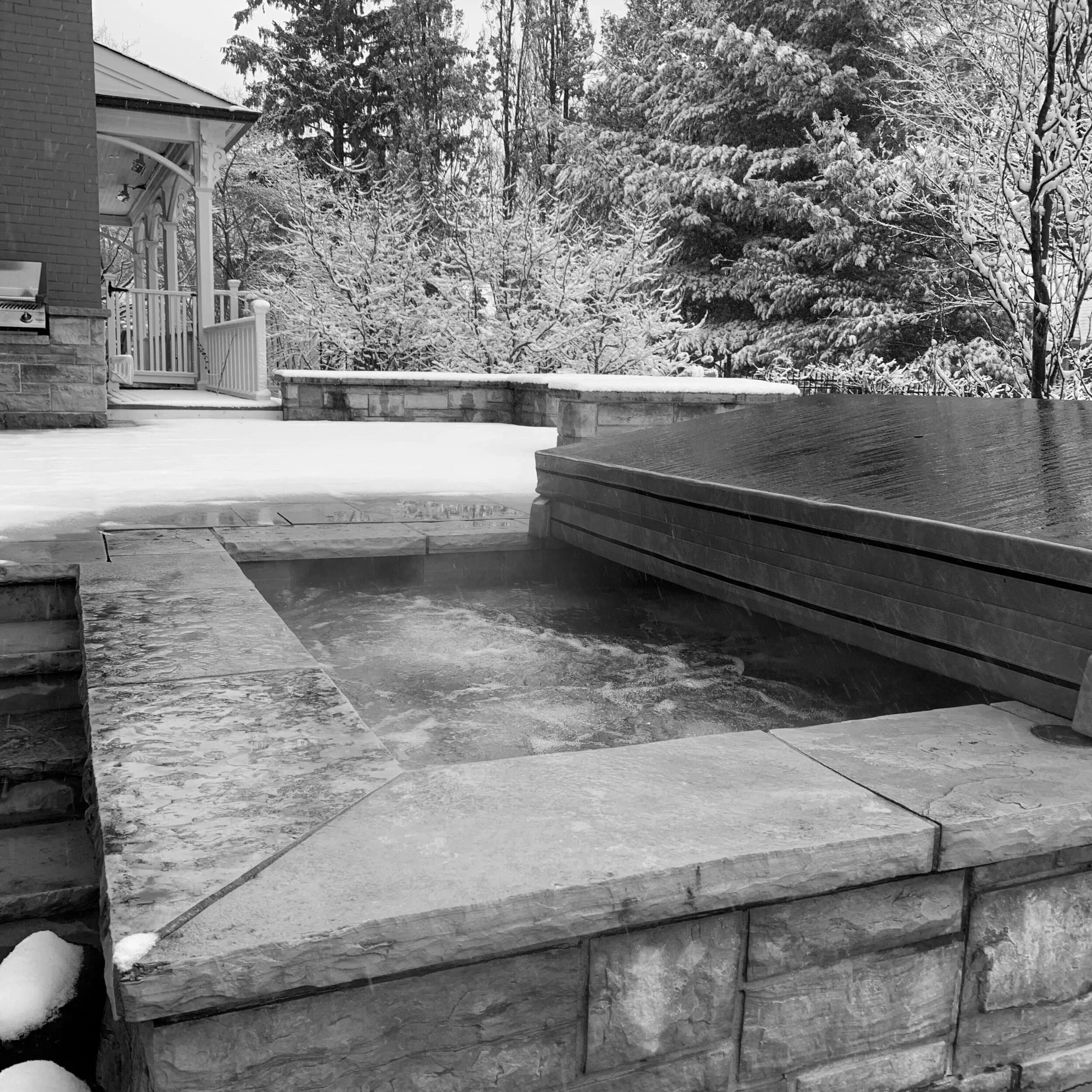 Heated outdoor water feature operating in winter conditions, maintaining warm water through snow-covered surroundings.