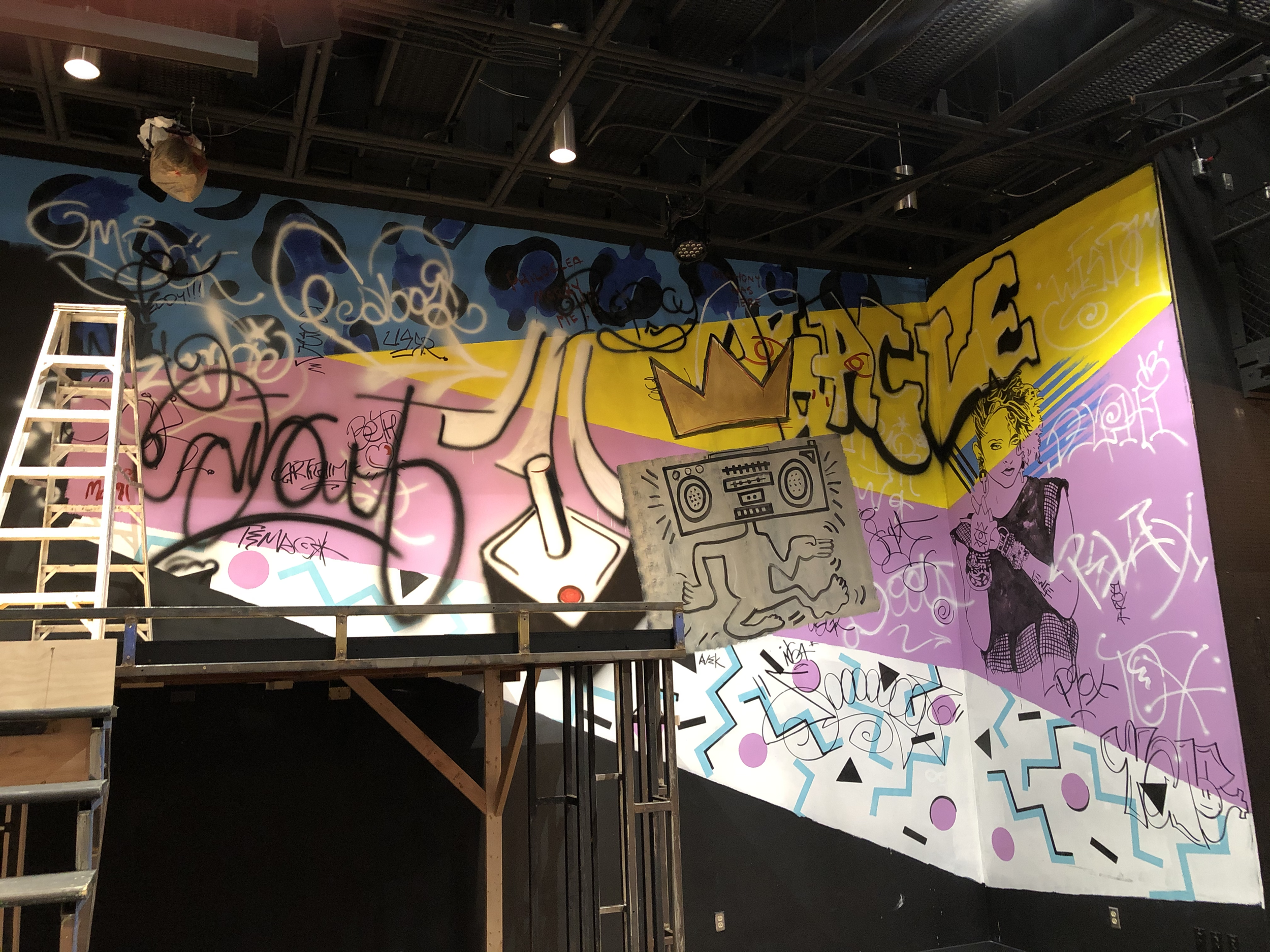 Graffiti wall featuring 80's graphic design and Keith Herring art.  I also let the cast come in and tag their names and add to the graffiti layers.  I like to utilize the cast in my design work where applicable.