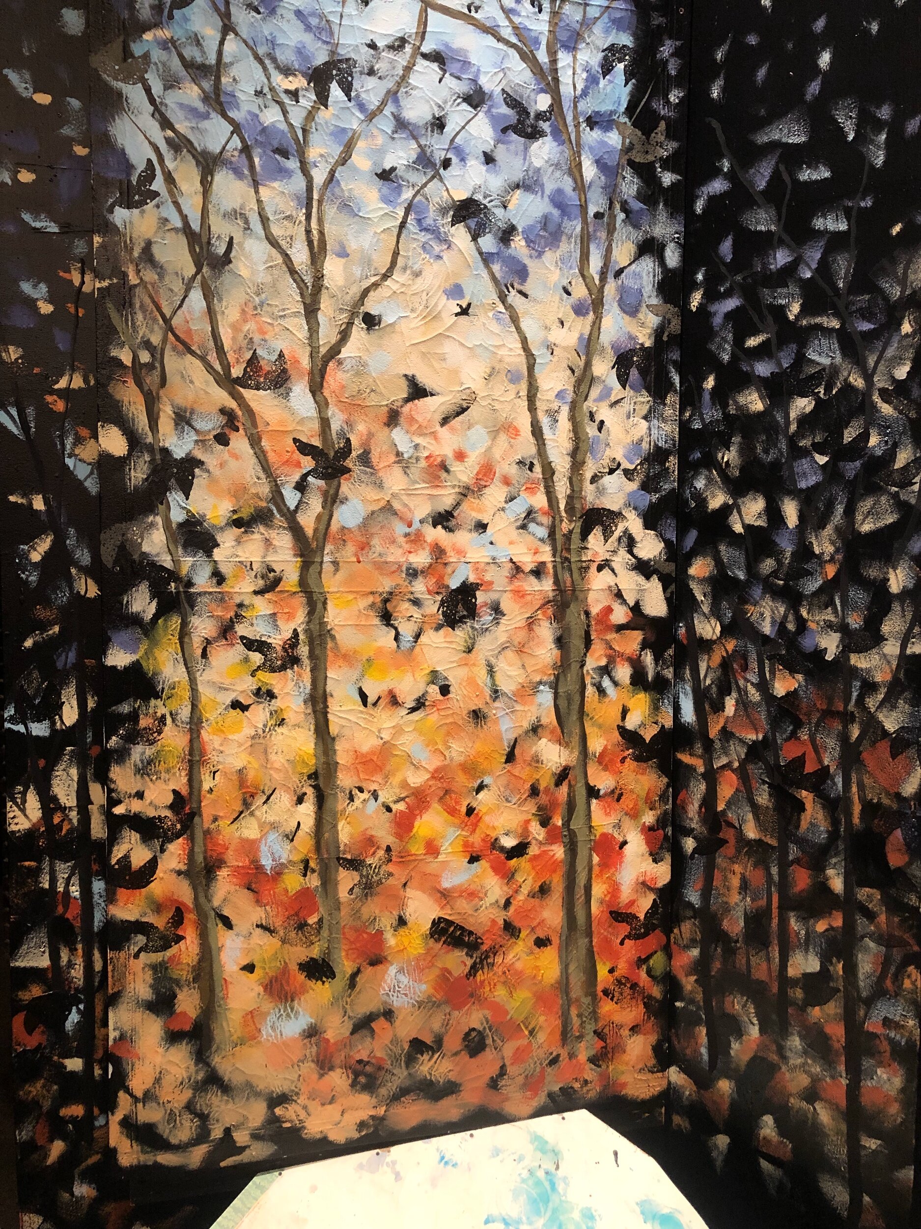 painted wall with painted trees to blend in the real trees