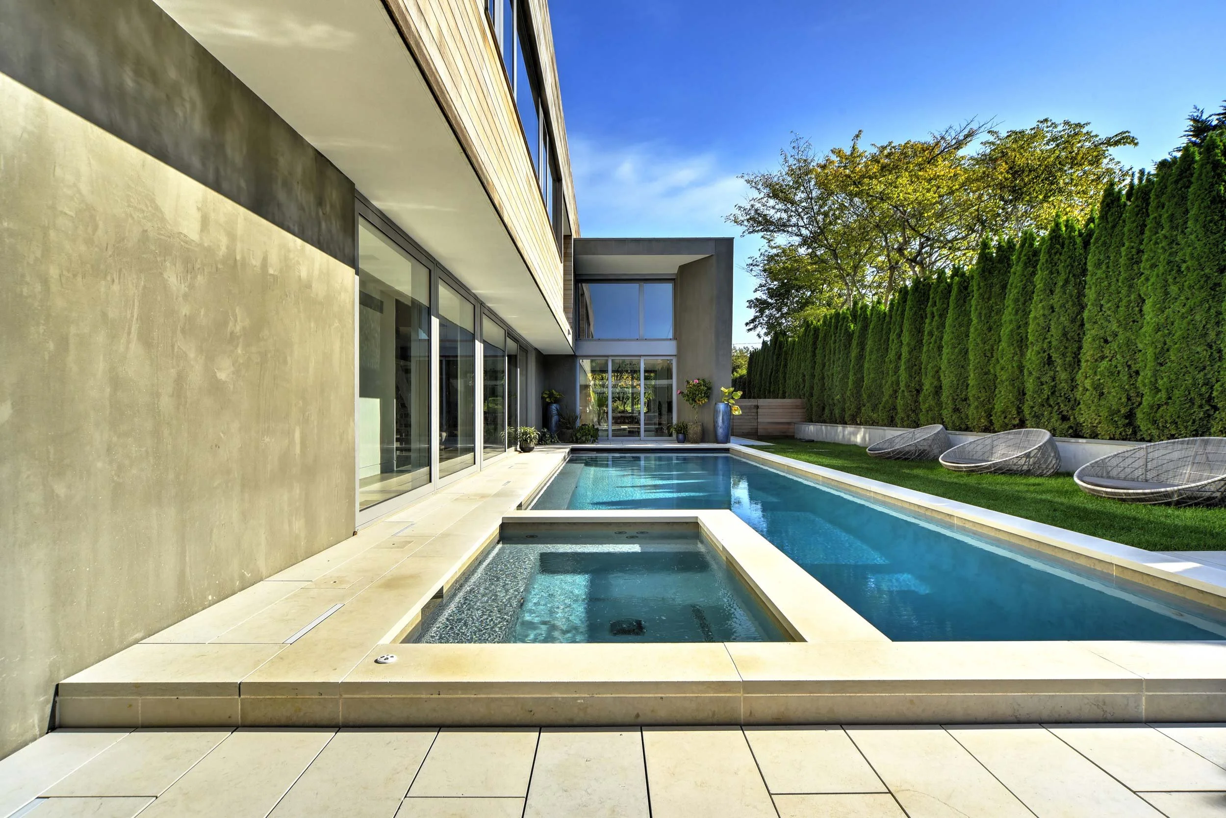 Afyon Cloud stone pool deck with outdoor lounge at Lane House modern residence