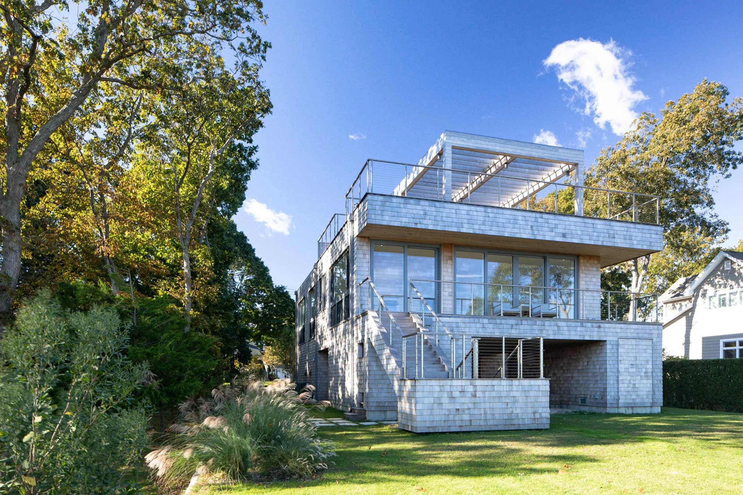 Oversized sliding glass doors framing water views in Bay Shore Road modern Greenport, North Fork home