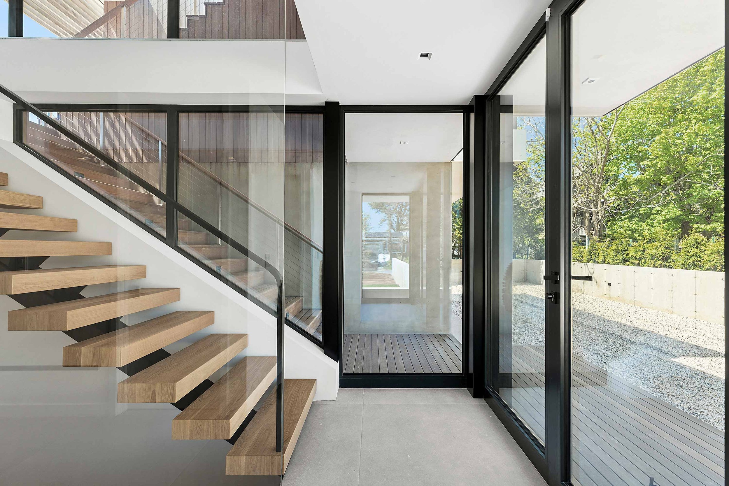 Modern East Hampton home with glass entrance and parallel staircase