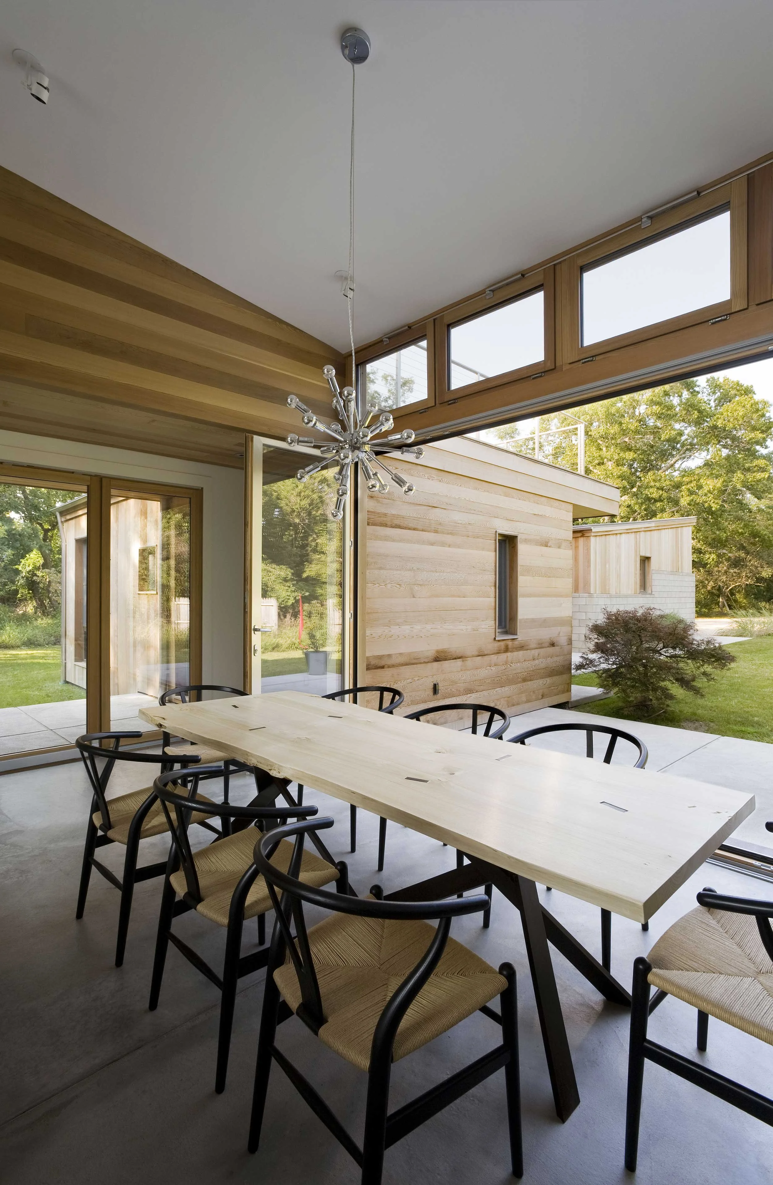 Dining room with large windows showcasing passive solar design at Old Stone Highway House
