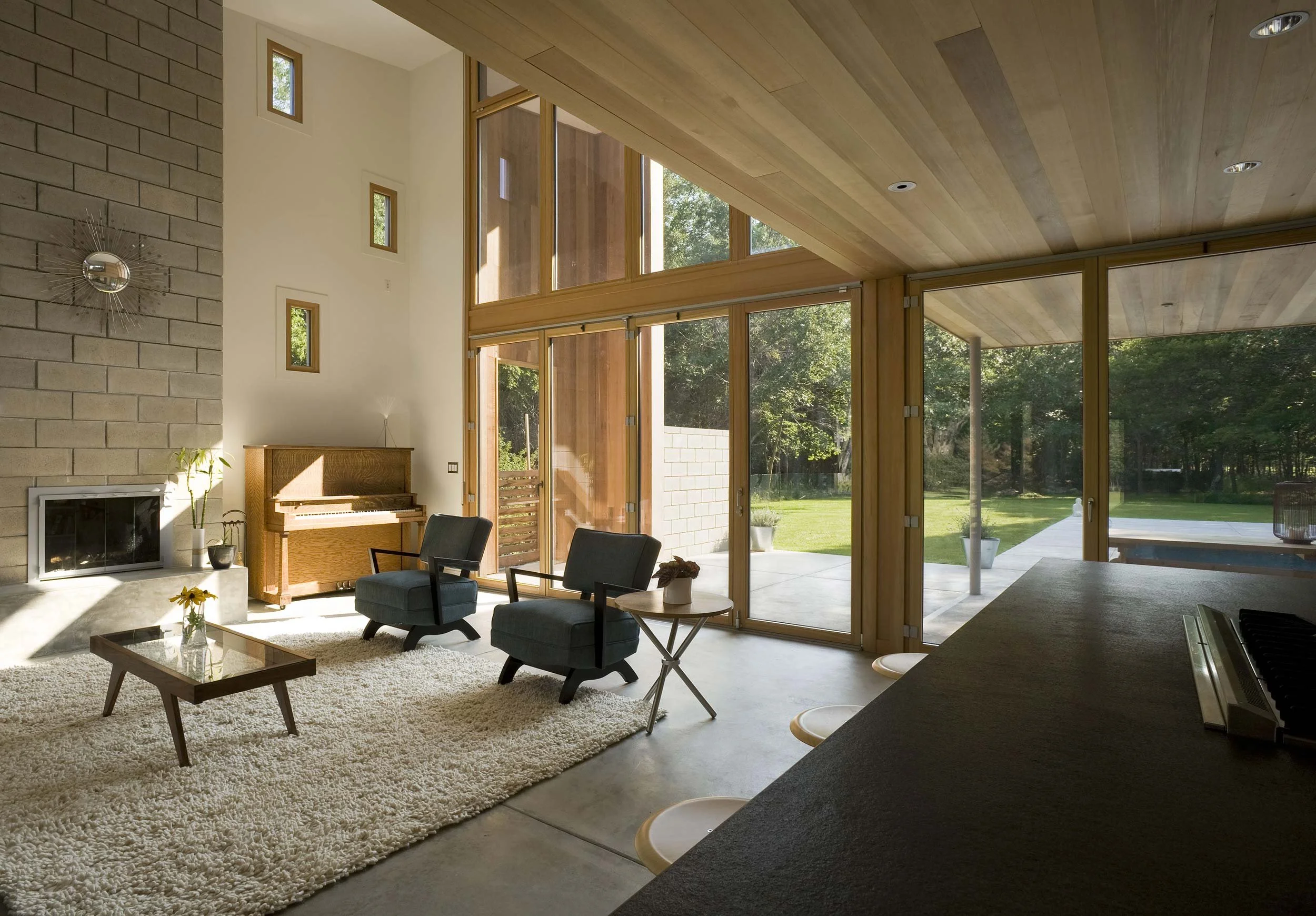 Living room with open plan layout, exposed beams, and natural light from passive solar design