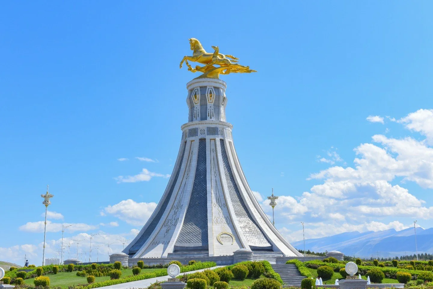 Ashgabat rises: a vision of minarets glinting against an endless sky. Here, marble palaces echo the ambitions of sultans, and sweeping white boulevards shimmer beneath the golden sun. Step into a realm of seductive contrasts, where Silk Road secrets 
