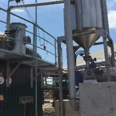 Steel hopper above screw press system installed outside of an anaerobic digestion facility