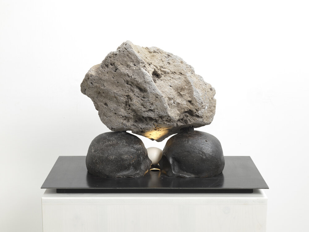 Metamorphosis Tiberio, 2012, rock, cast-iron skull, steel, egg, light, wooden podest, 130 x 60 x 30 cm