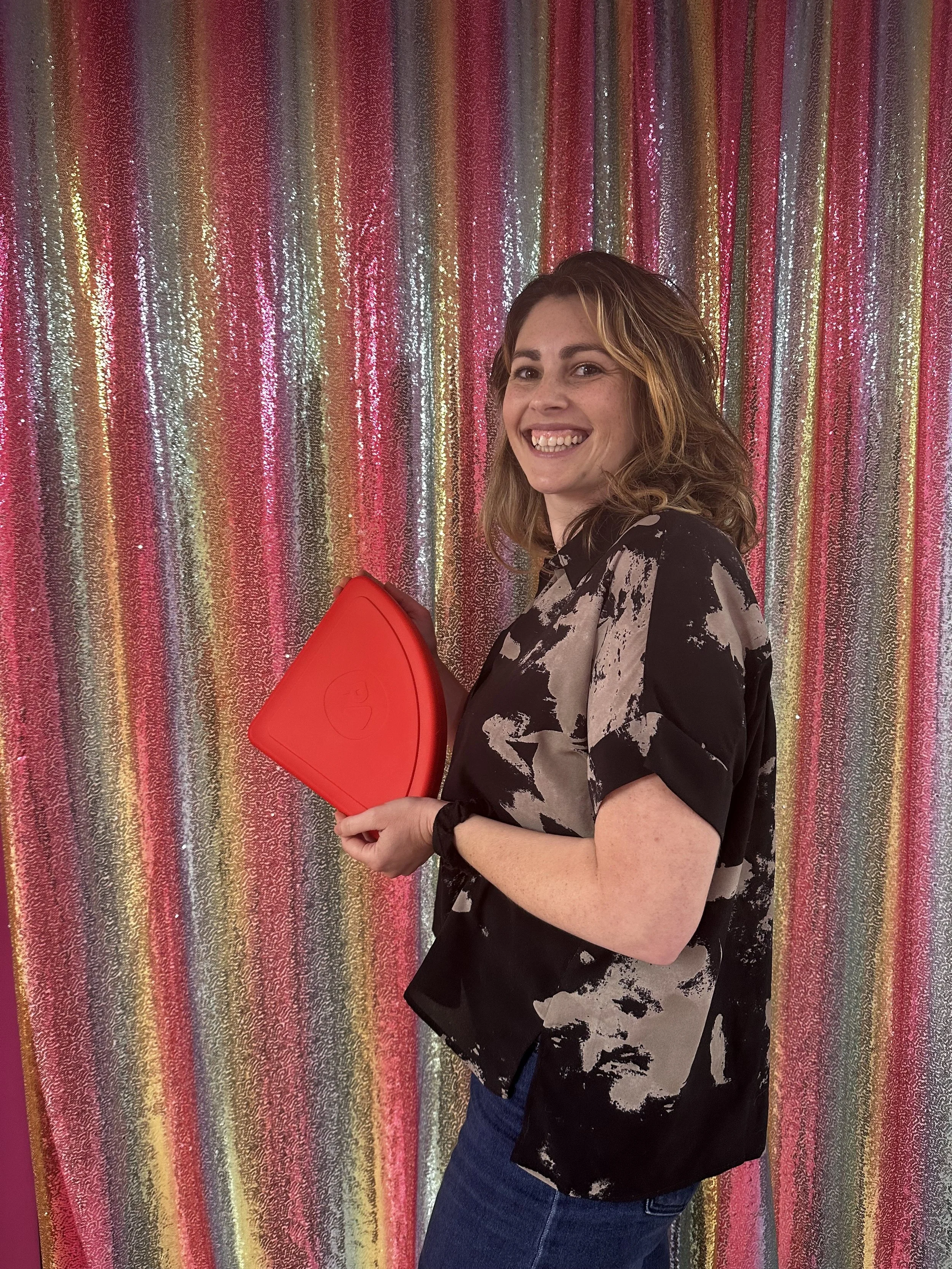 Heather, founder and creator of Pizza Pal LLC, holding a Saucy Red silicone Pizza Pac™.