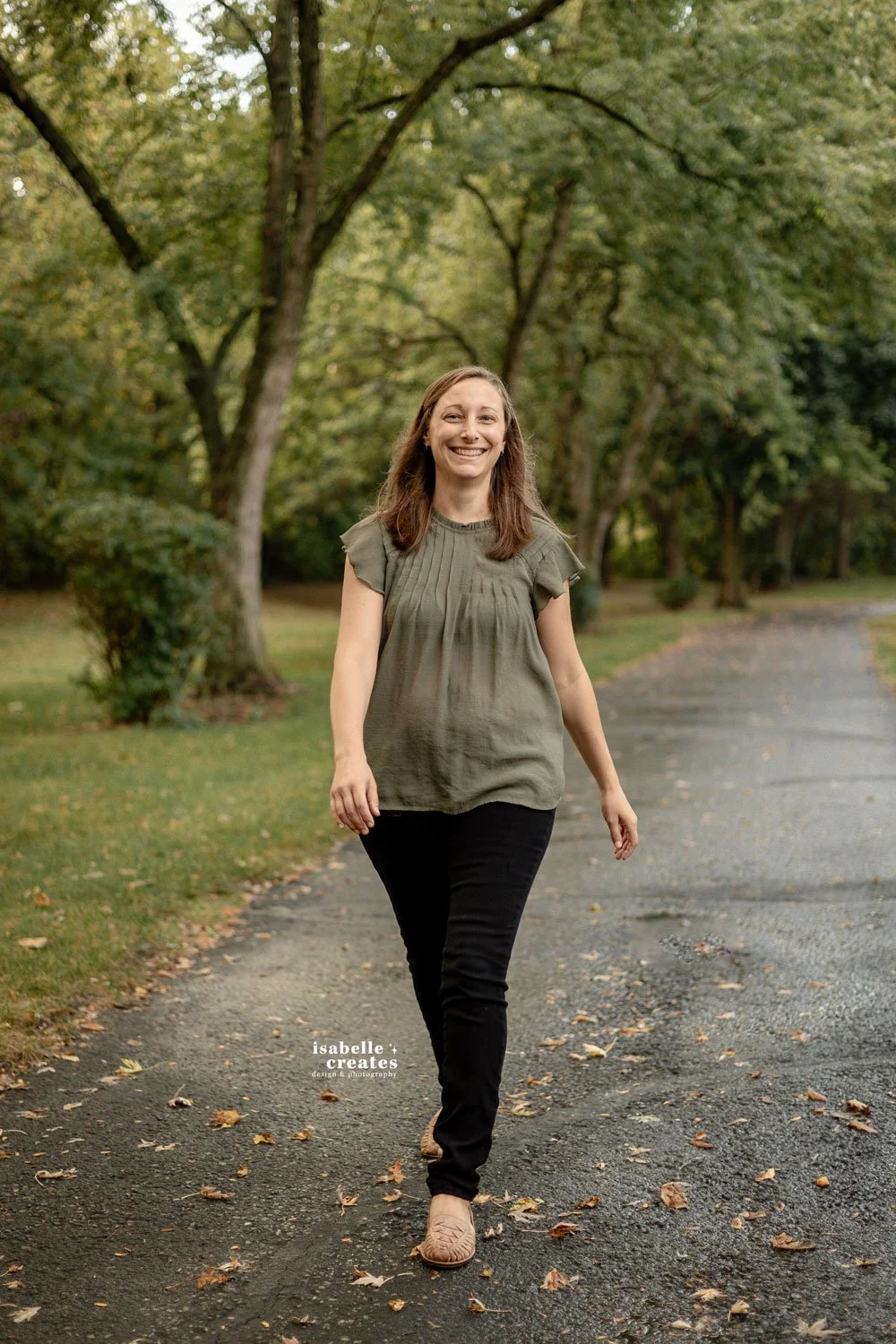 Woman in green walking down a path in a park in Indiana.