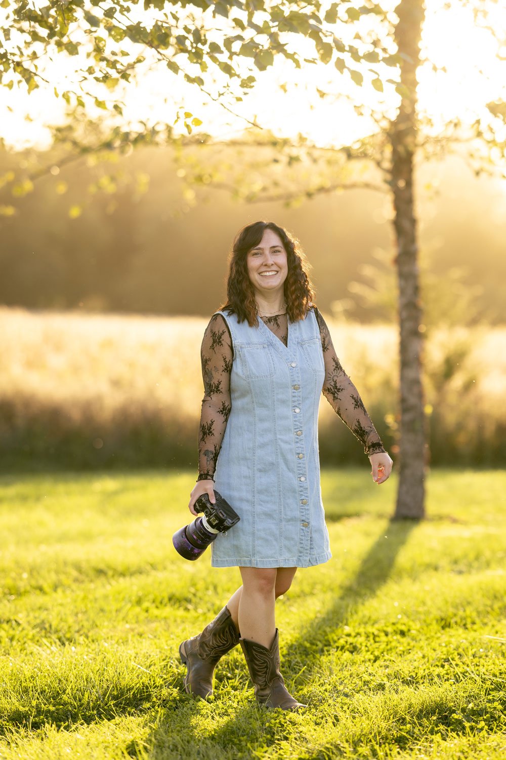 Isabelle Kroeker, graphic designer and photographer stands with her camera in cowboy boots