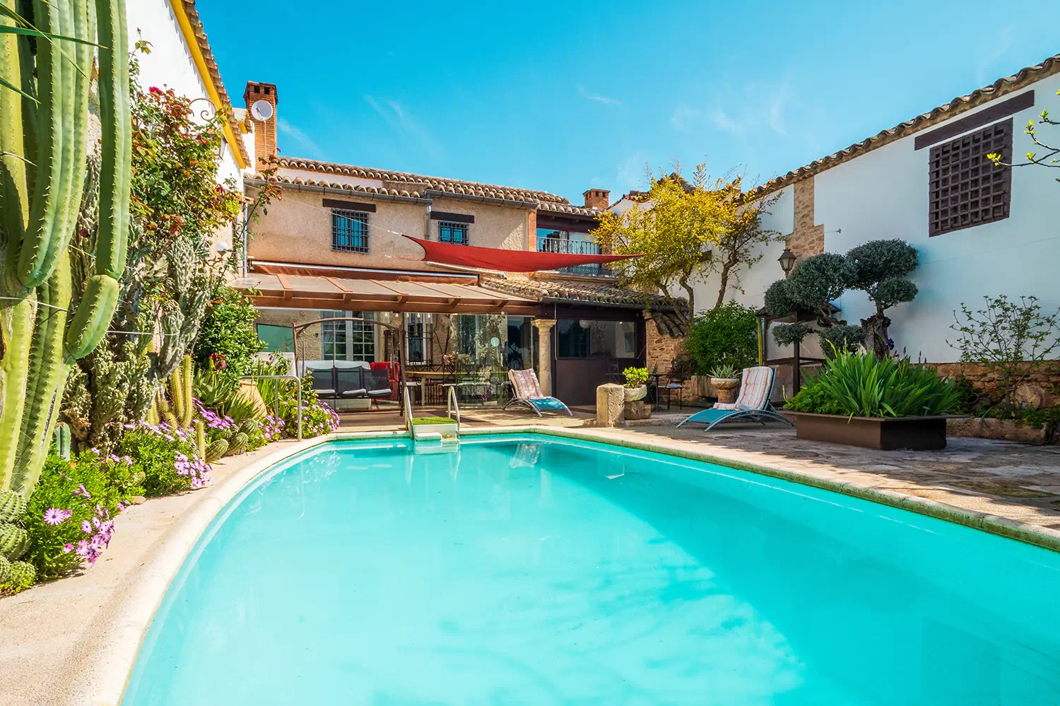Piscina privada y patio exterior de casa rural para grupos en Almagro con zona de descanso y jardín