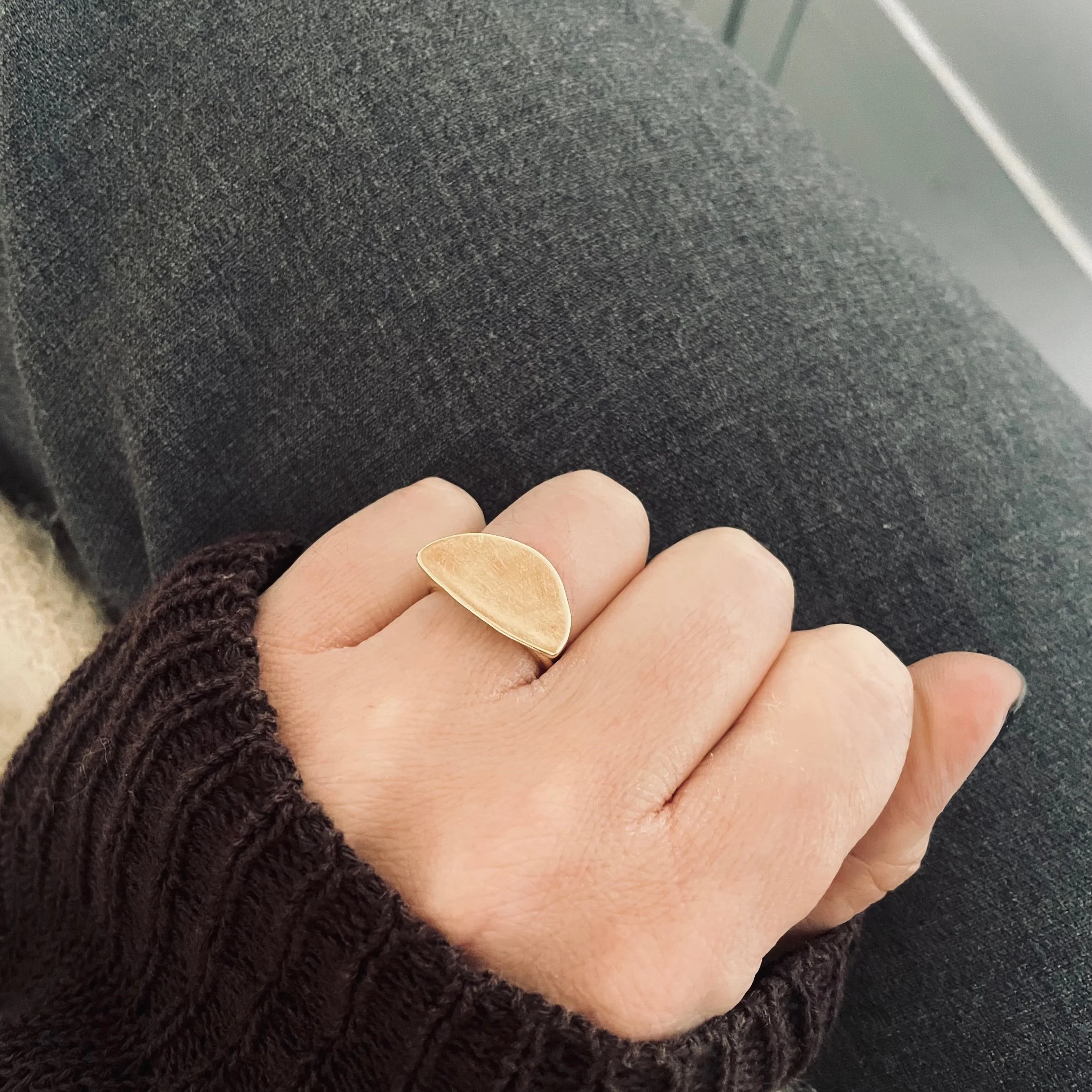 Handmade solid recycled gold ring in the shape of a rough half circle, textured, photographed worn