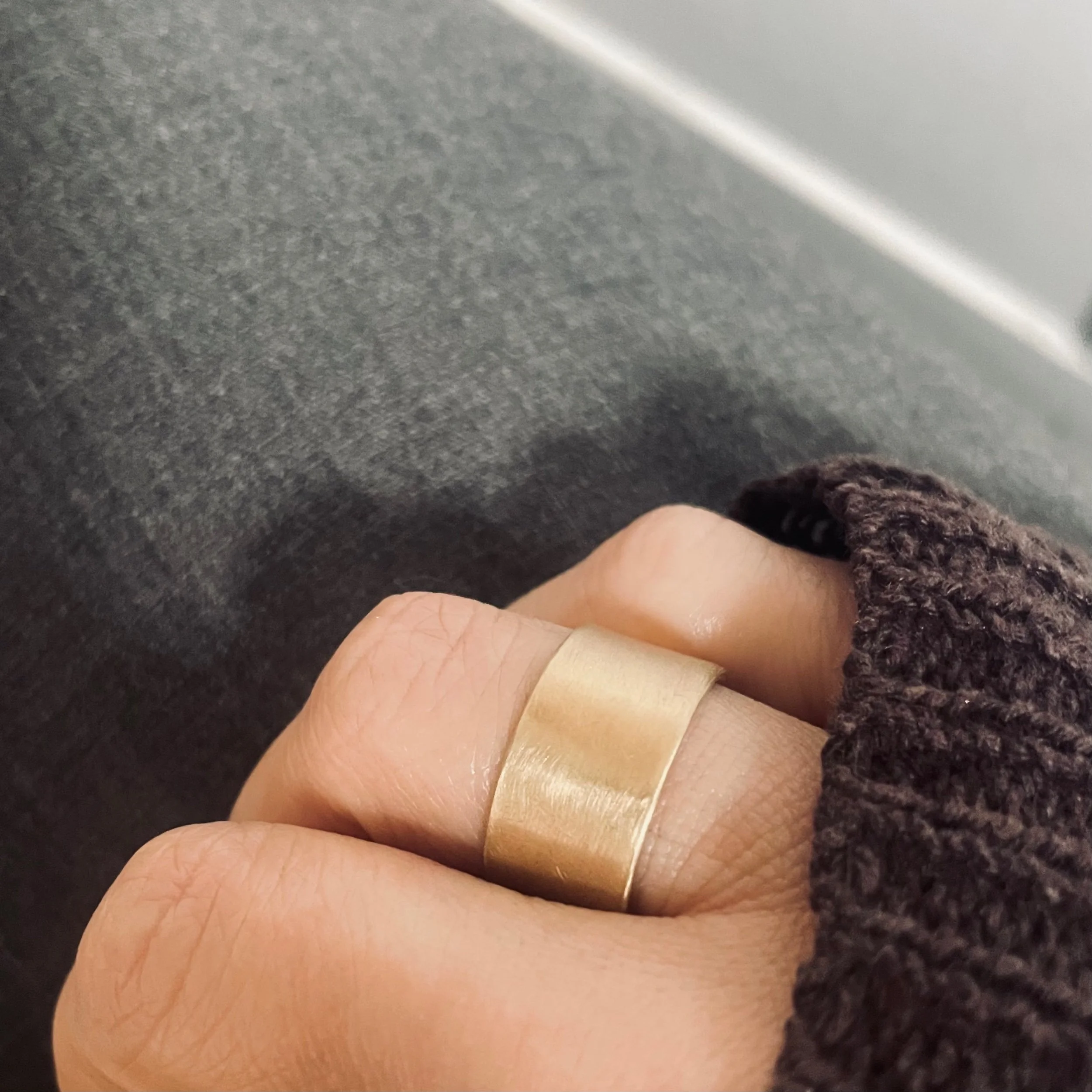 Handmade wide band solid recycled gold ring photographed worn