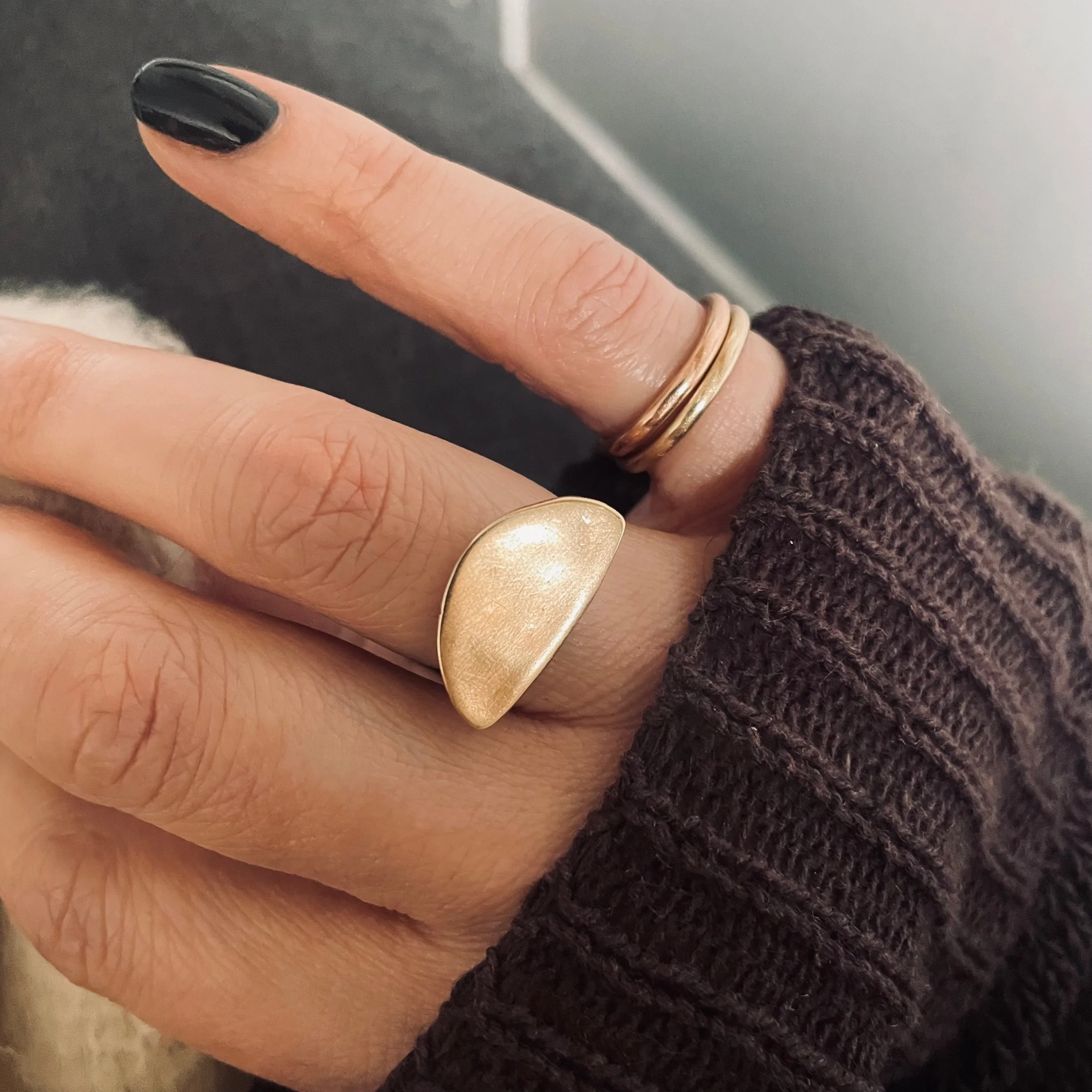 Handmade solid recycled gold ring in the shape of a rough half circle, textured, photographed worn