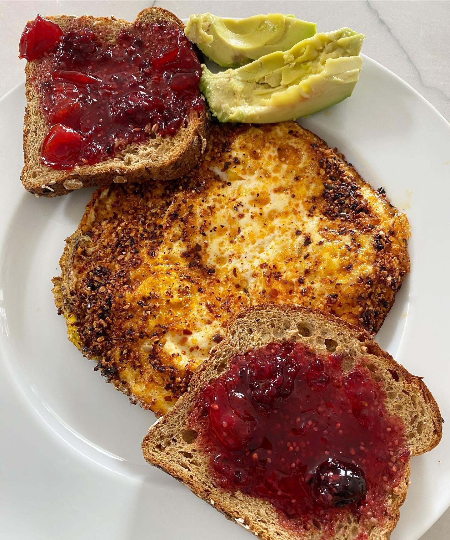 My go-to post-workout breakfast that checks all of the boxes. 🥑🍳This savory, sweet, and spicy combo is simple, satisfying, and delicious!

Fried eggs in garlic chili crunch oil with toast topped with avocado and a locally produced jam. 

I&rsquo;m 