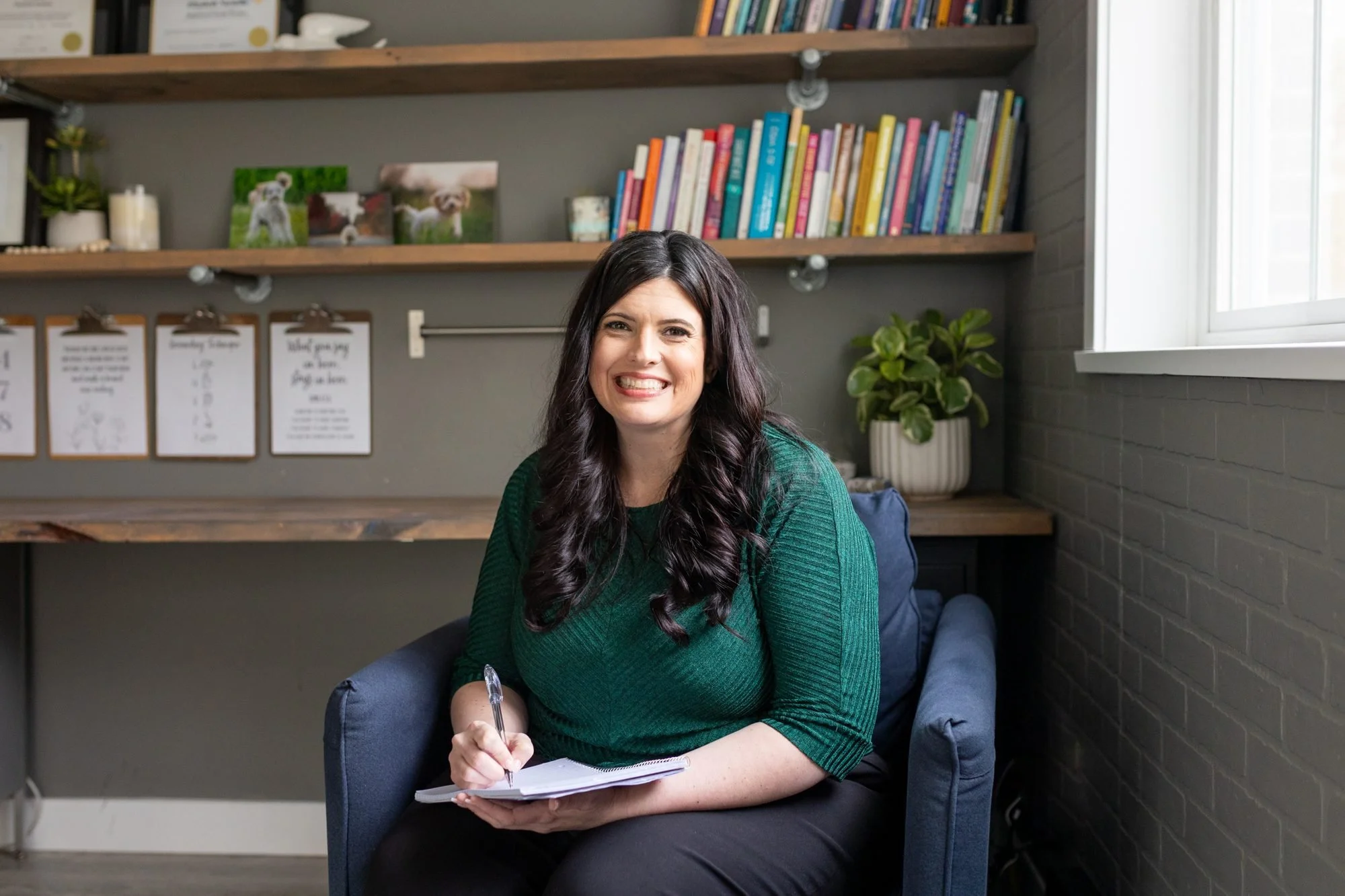 Elizabeth Nardella writing notes in an armchair in her counselling office