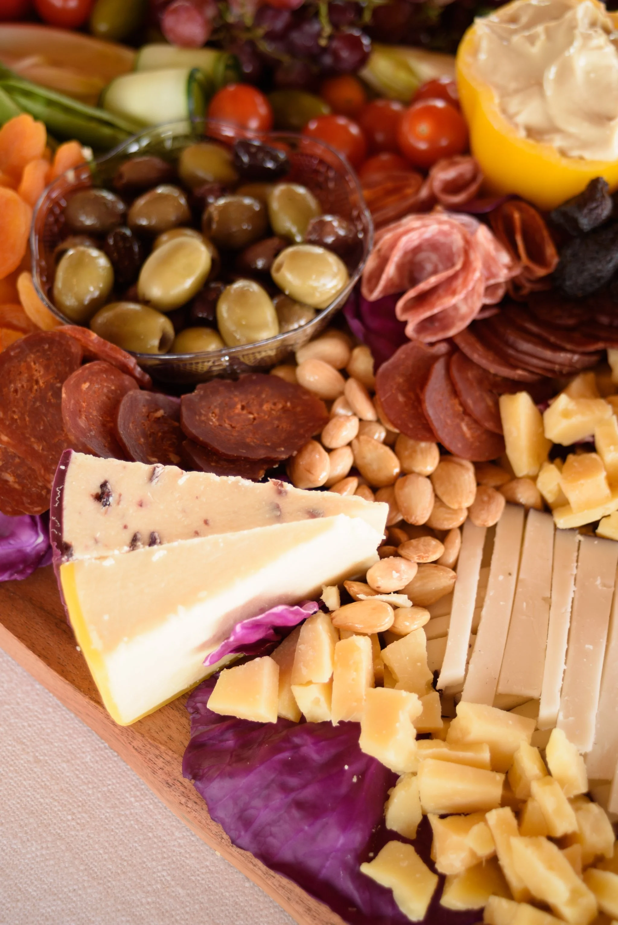 A cheese platter from the Cheese Corner in Westerly with a variety of sliced and crumbled hard and soft cheeses, charcuterie, fruits, olives, nuts, fig jam and honey. 
