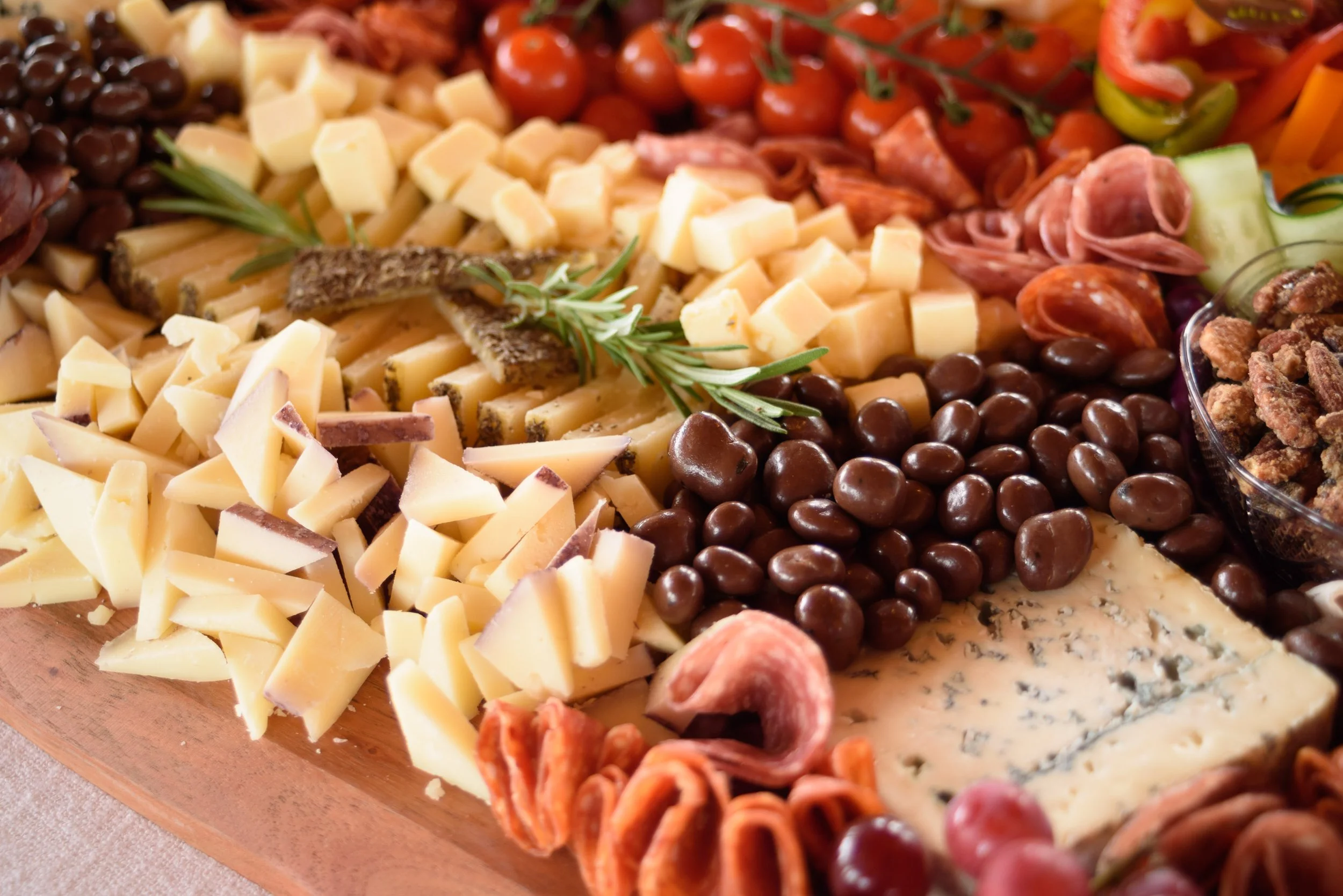 A cheese platter from the Cheese Corner in Westerly with a variety of sliced and crumbled hard and soft cheeses, charcuterie, fruits, olives, nuts, fig jam and honey. 