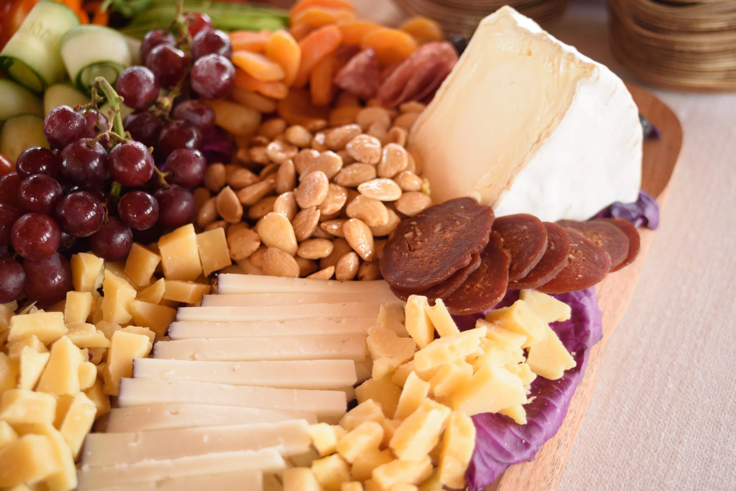 A cheese platter from the Cheese Corner in Westerly with a variety of sliced and crumbled hard and soft cheeses, charcuterie, fruits, olives, nuts, fig jam and honey. 