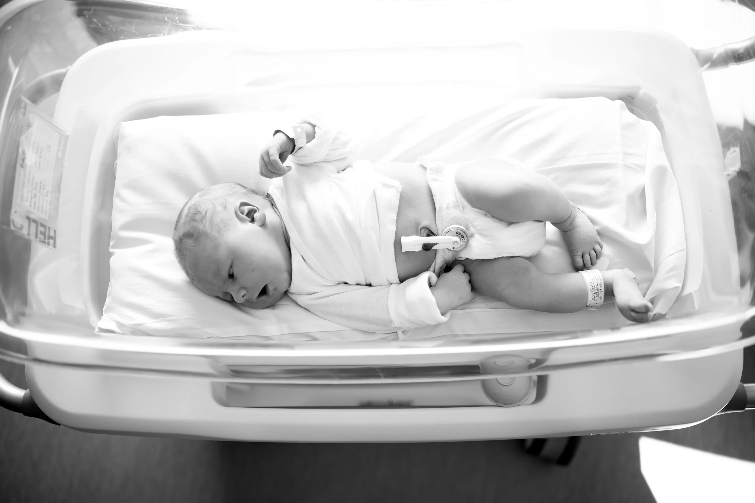 Overhead shot of a newborn baby lying in a hospital crib.