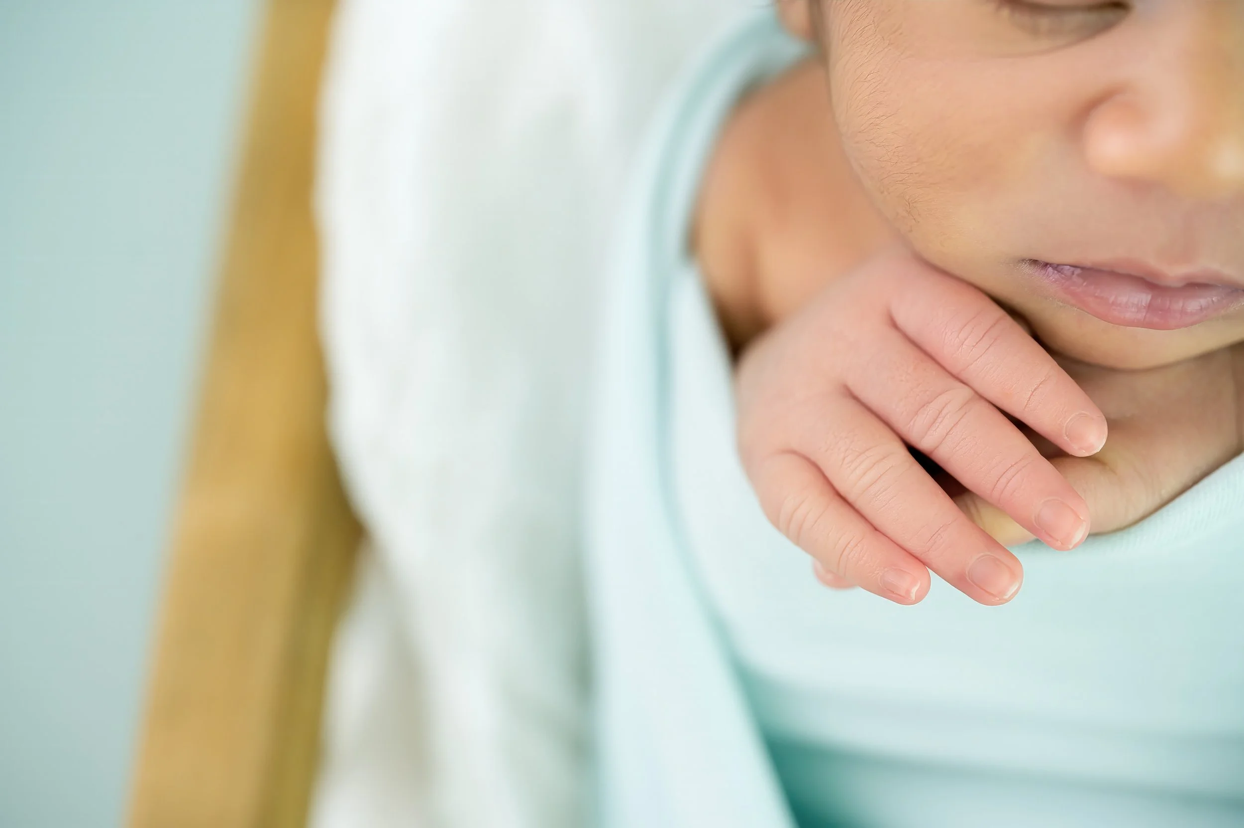 Close-up of a child's face with a pensive expression, gently touching their chin with their hand.