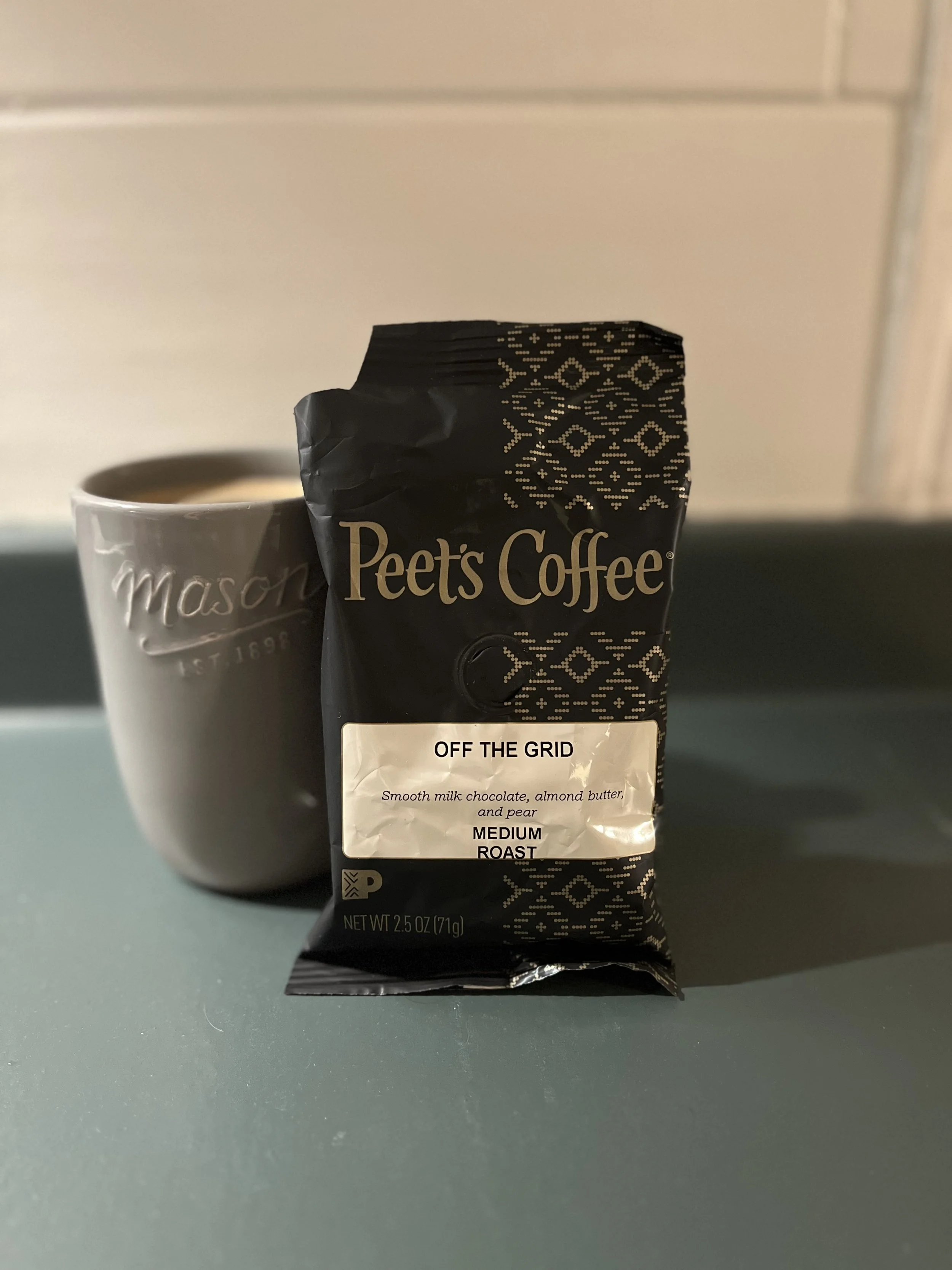 coffee mug next to bag of coffee grounds