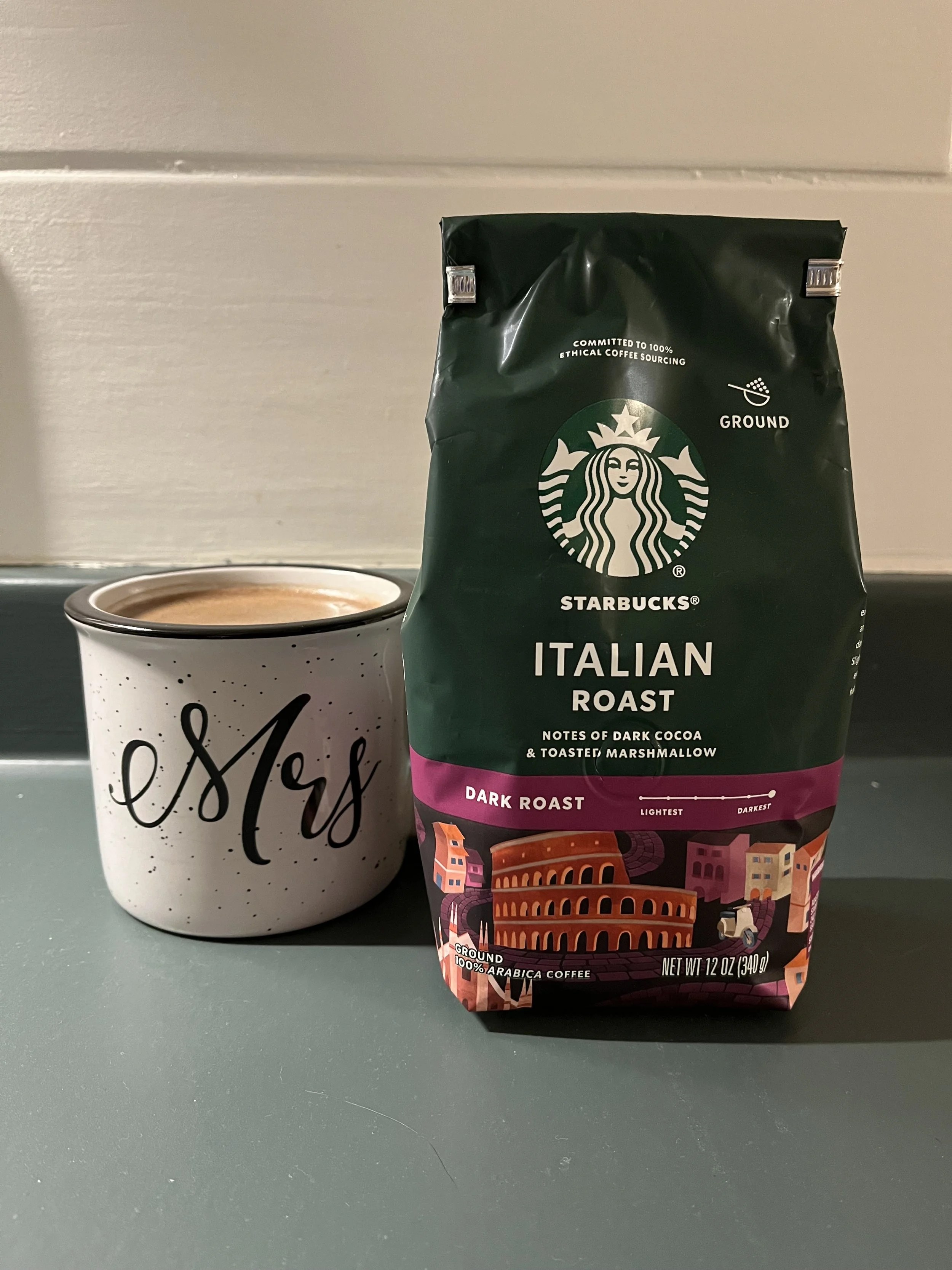 mug of coffee next to bag of Starbucks coffee grounds