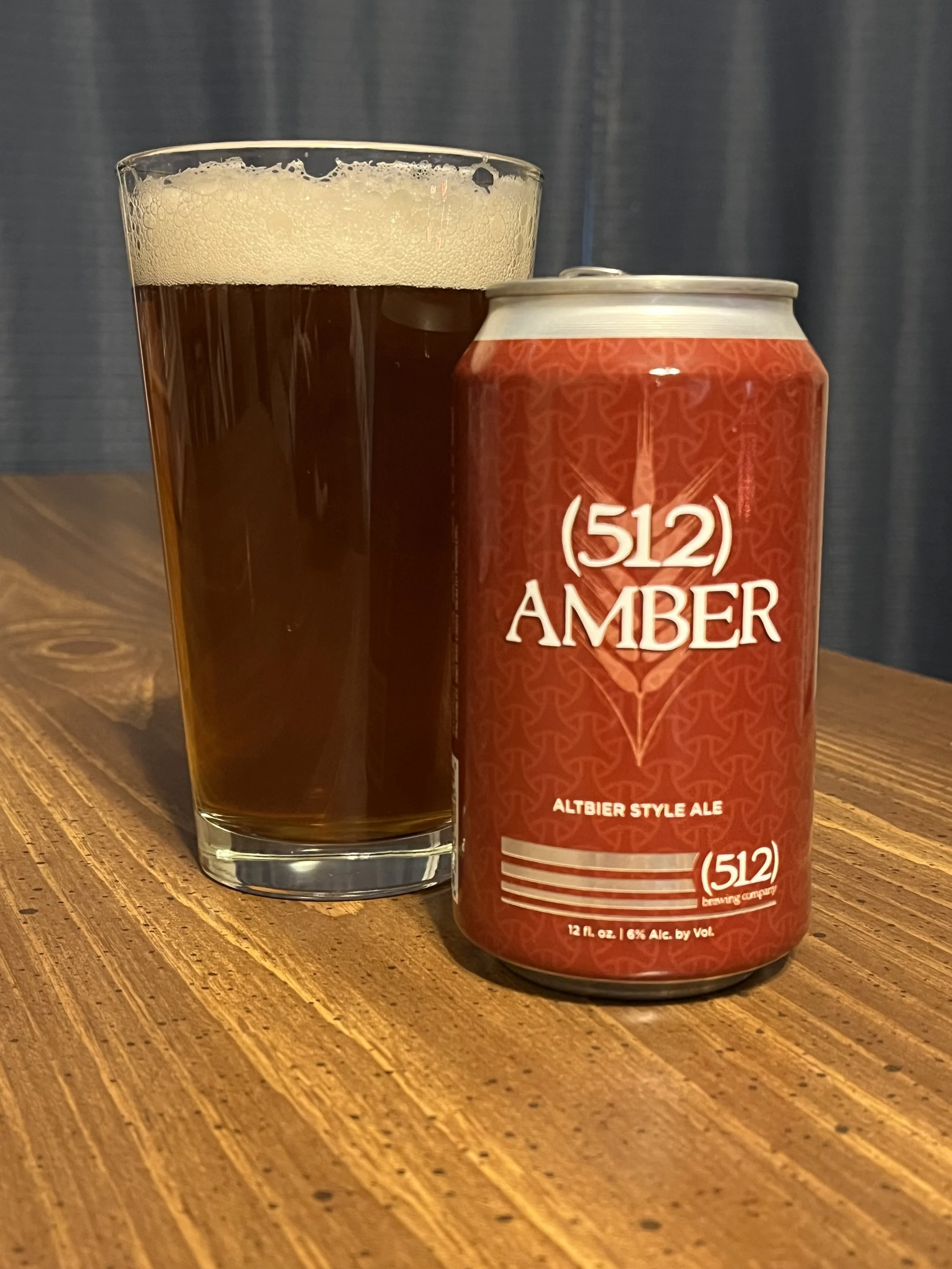 pub glass next to a (512) Beer can