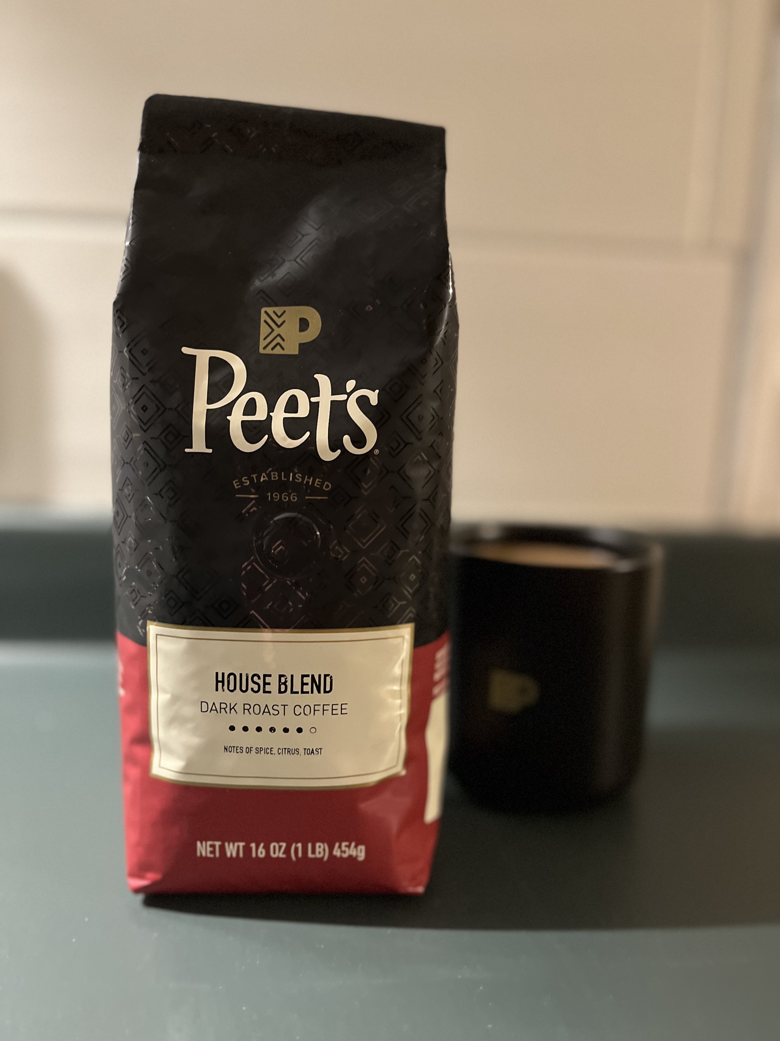 bag of coffee beans next to coffee mug
