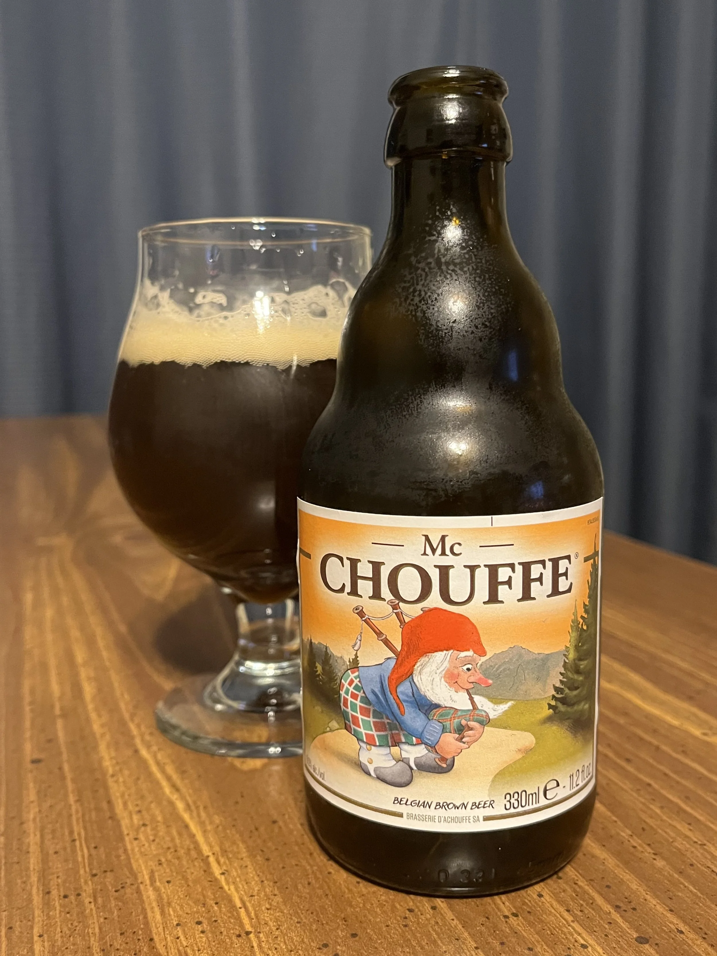 tulip glass next to bottle of Mc Chouffe Belgian beer