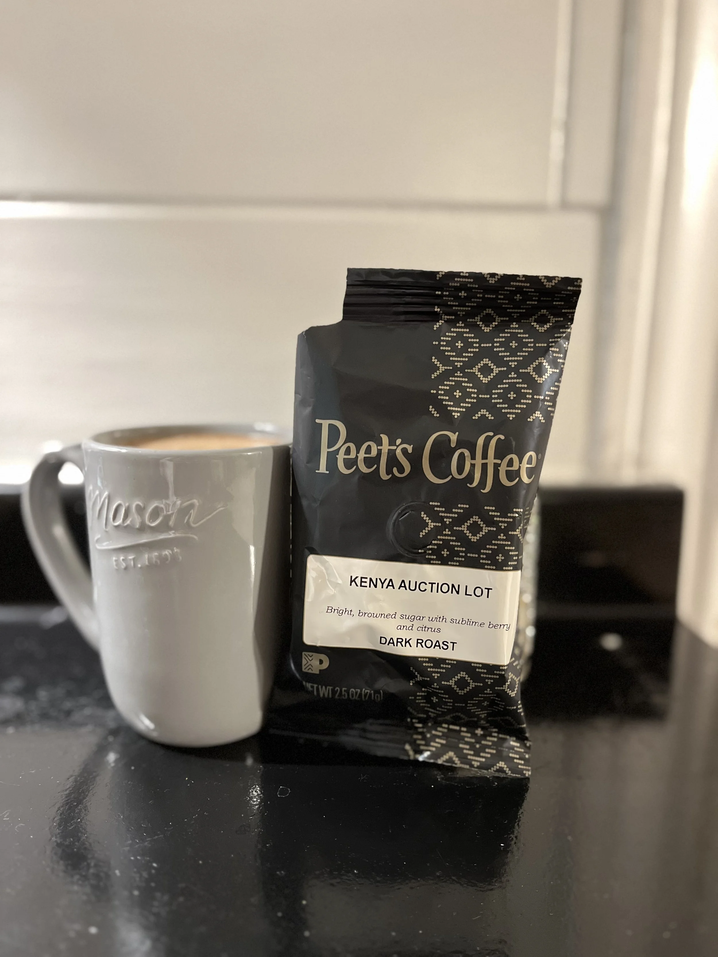 mug of coffee next to bag of coffee grounds