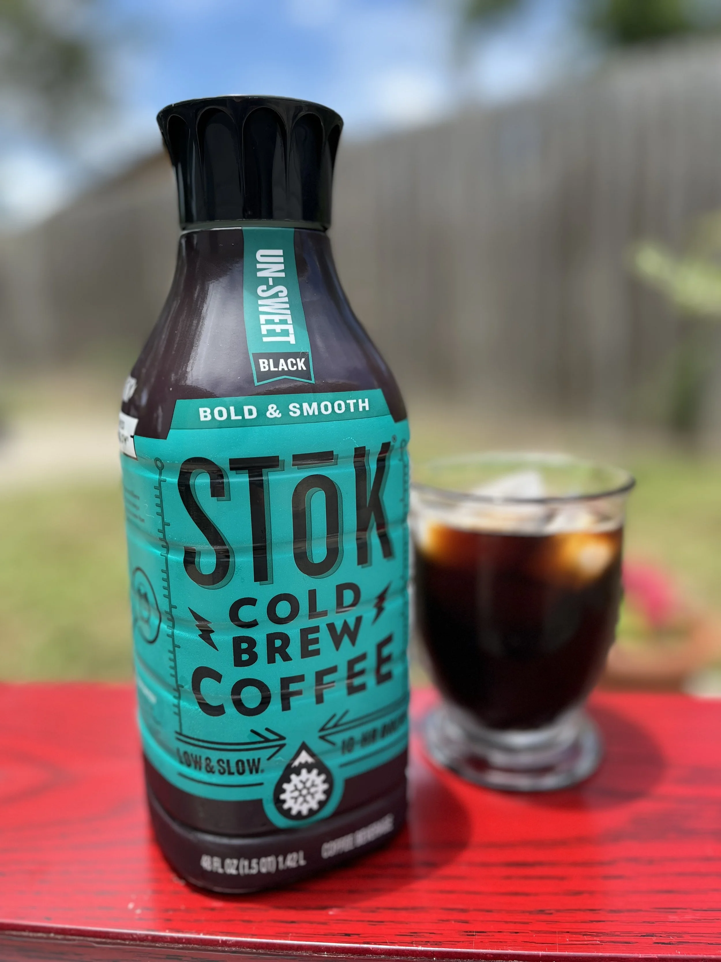 jug of cold brew next to glass of iced cold brew