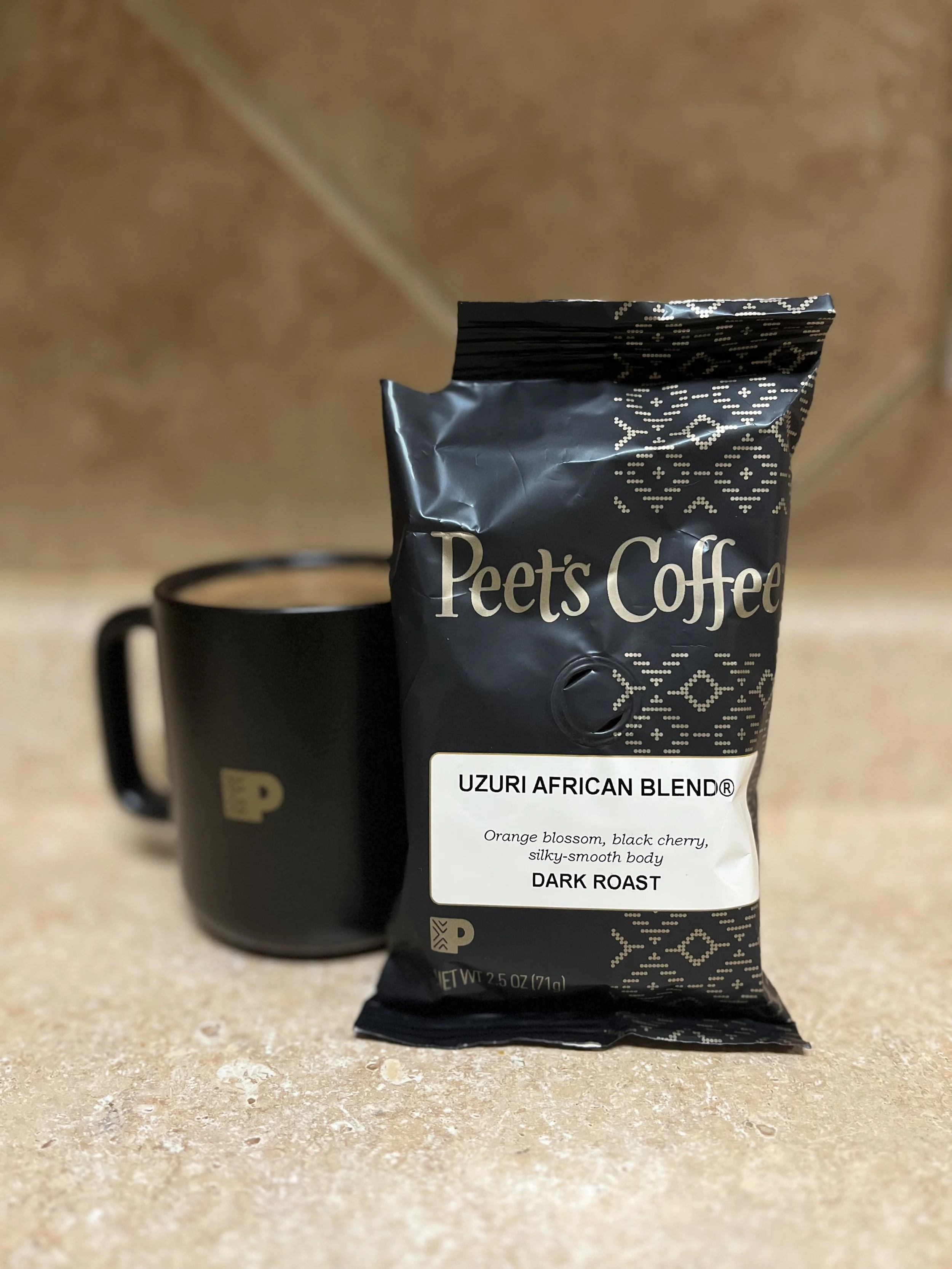 mug of coffee next to bag of peet's coffee
