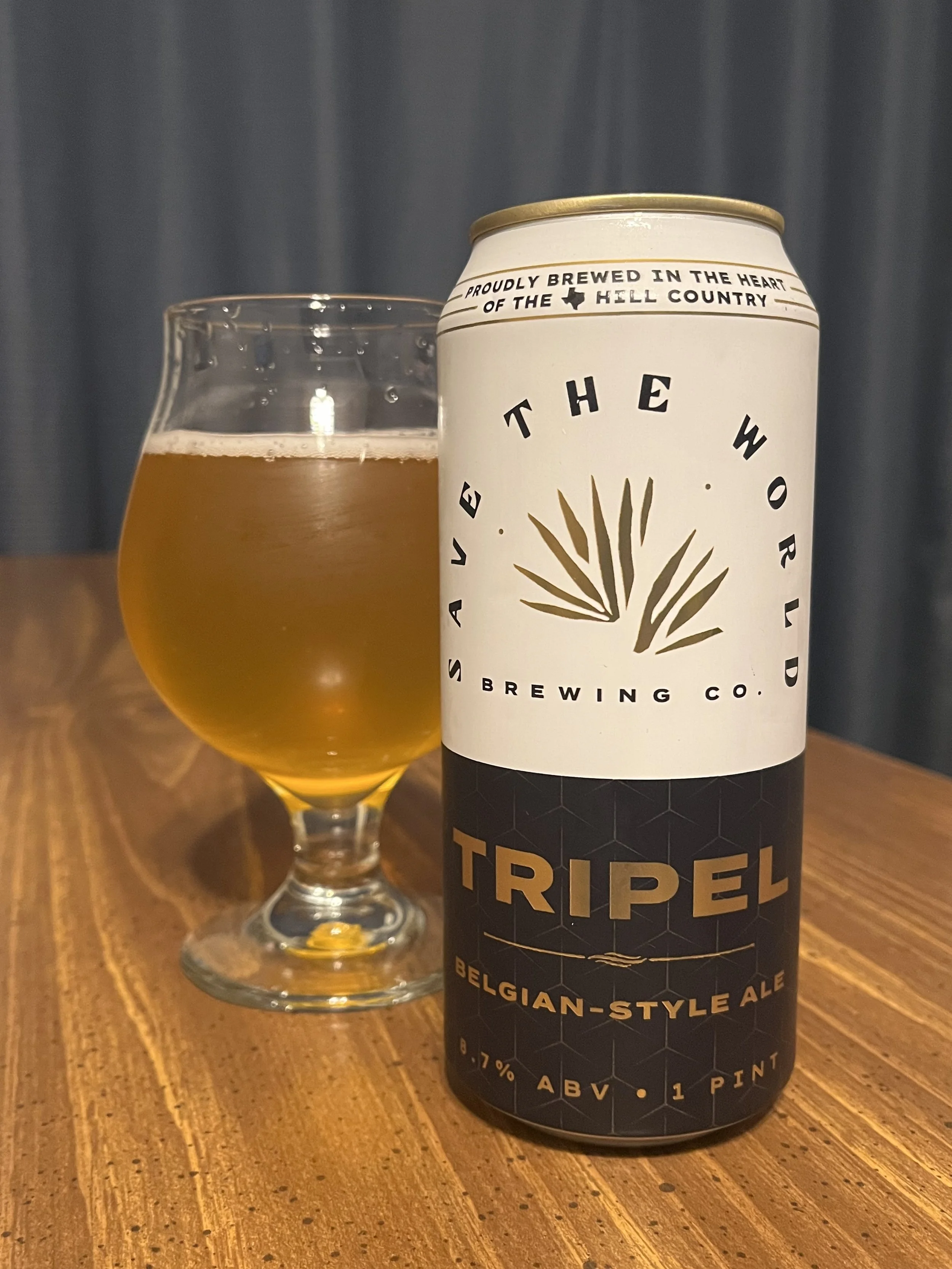 tulip glass with beer next to beer can from Save the World Brewing