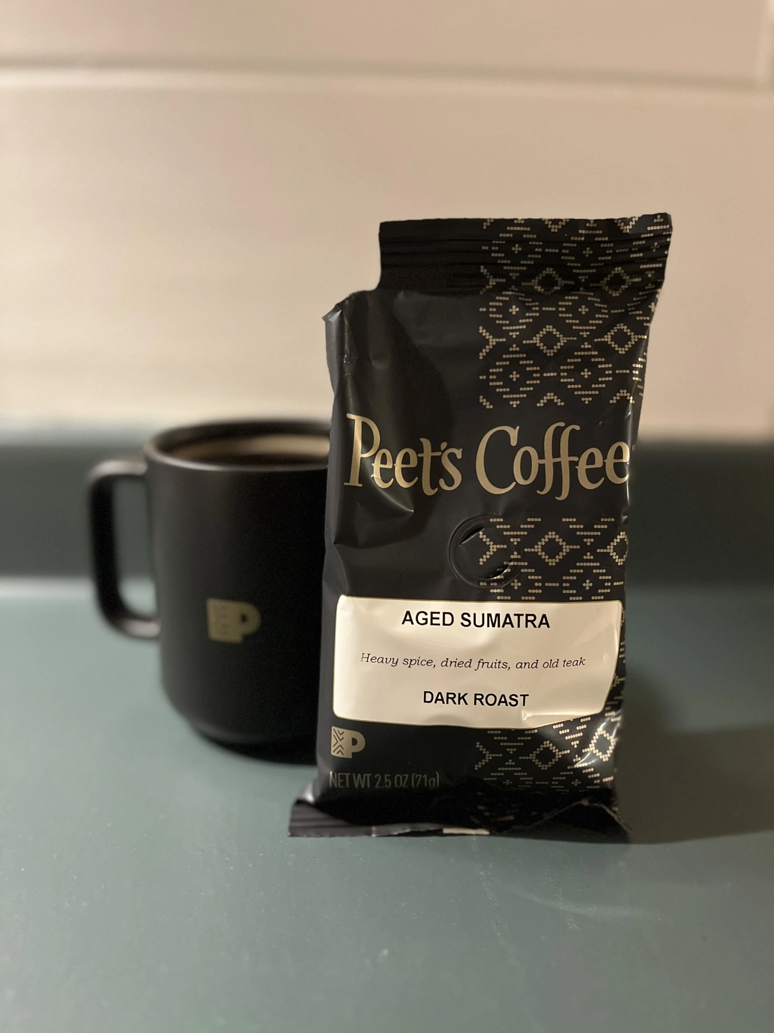 mug of coffee next to bag of coffee grounds