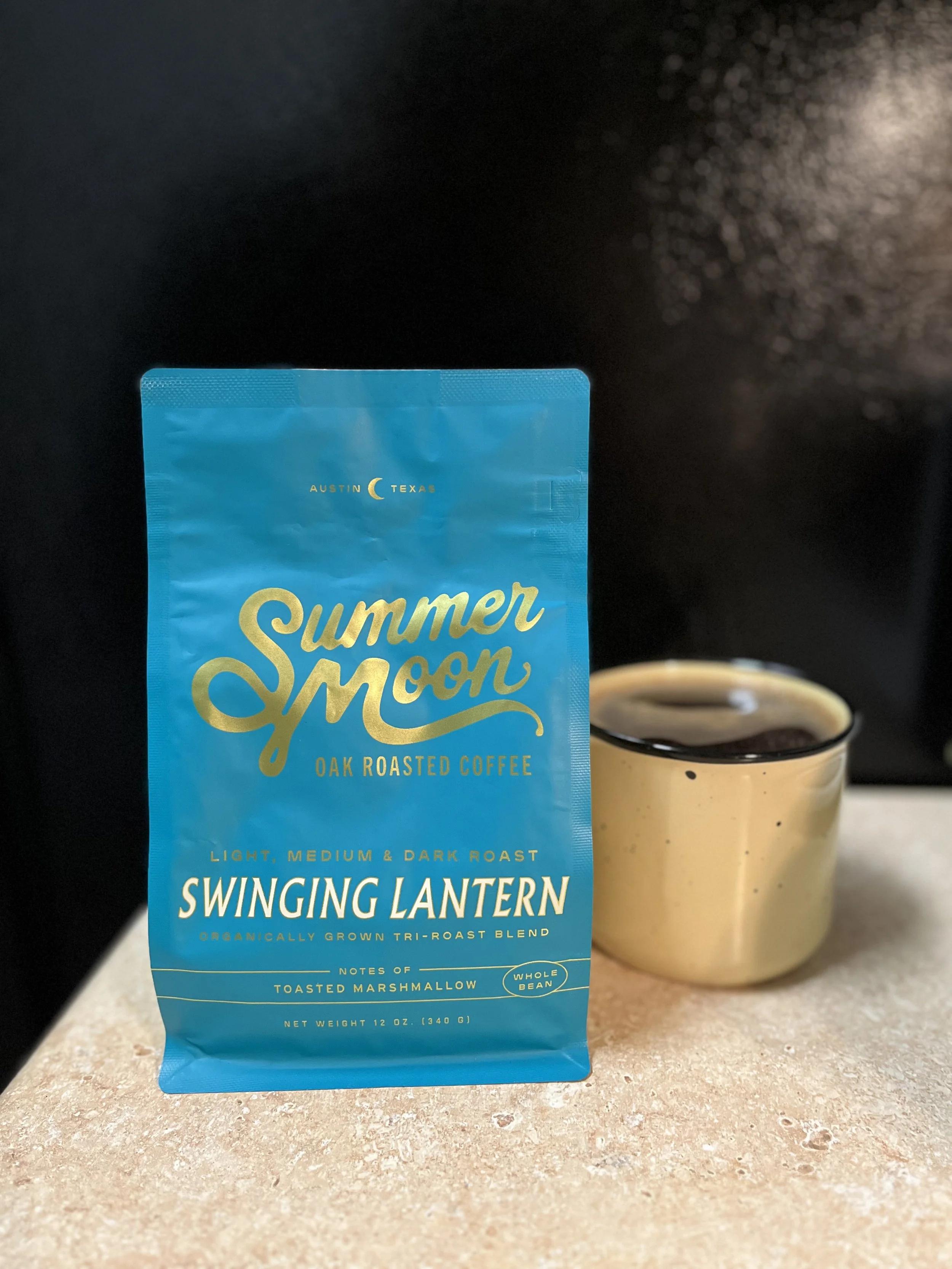 bag of coffee beans next to a mug of coffee